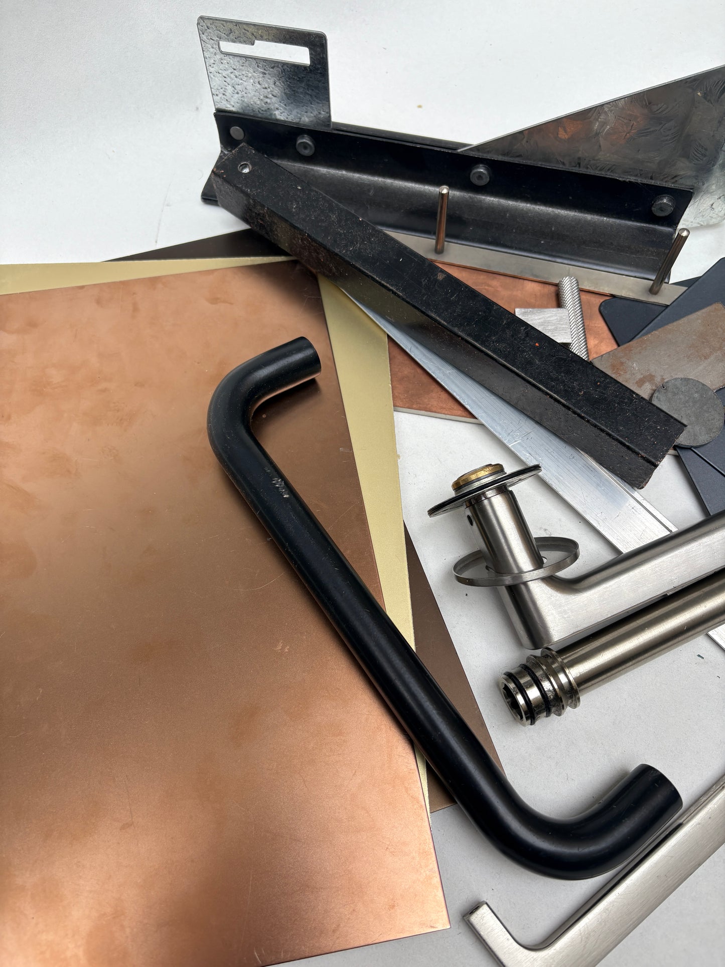 Various metal sheets, rods, and handles are shown together