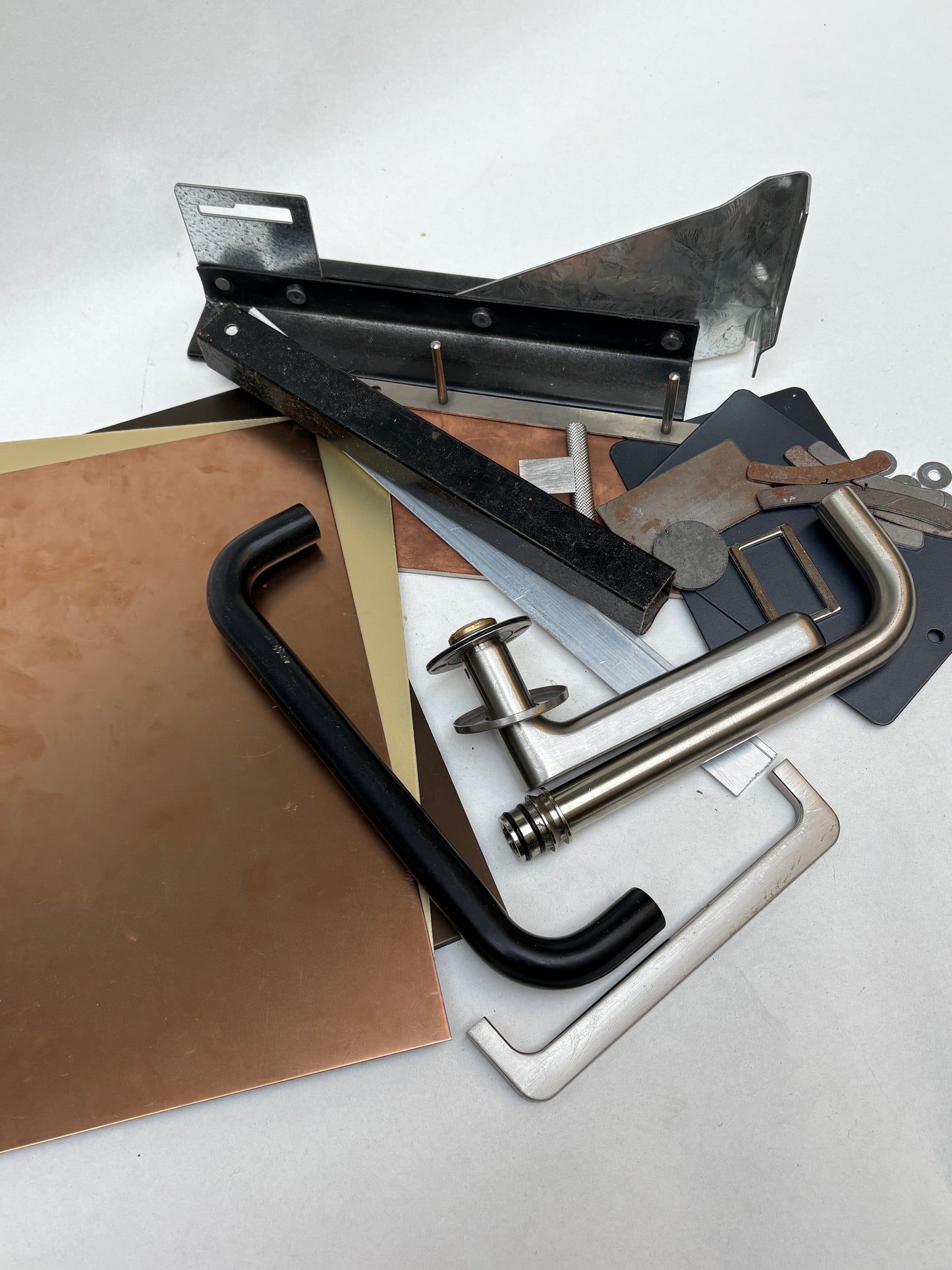 A mixed bundle of metal samples lies on a white surface