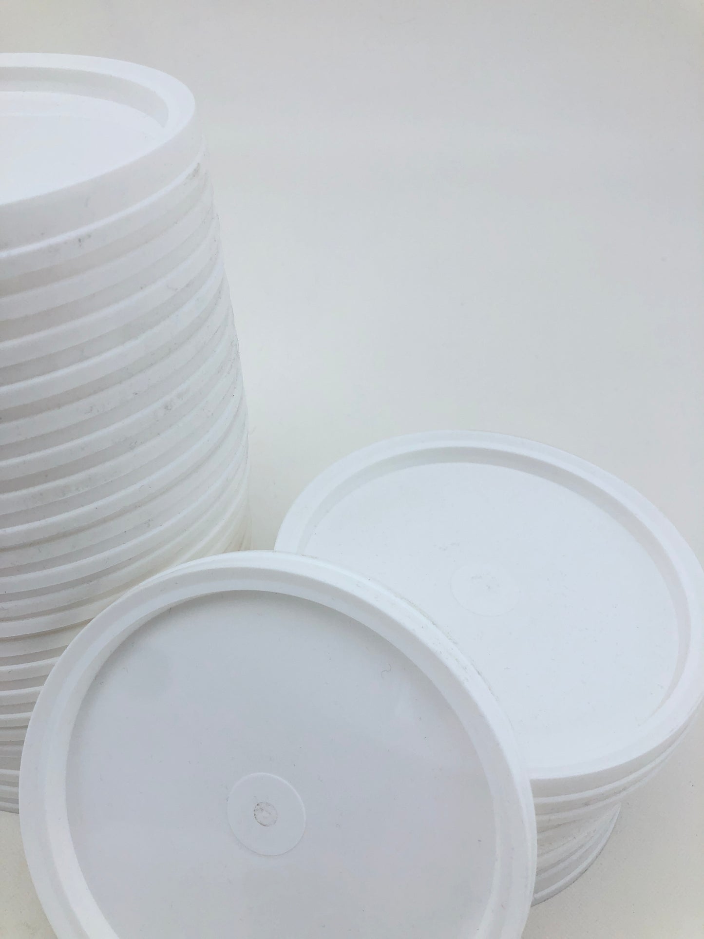 Small white paint palettes are grouped together on a white surface