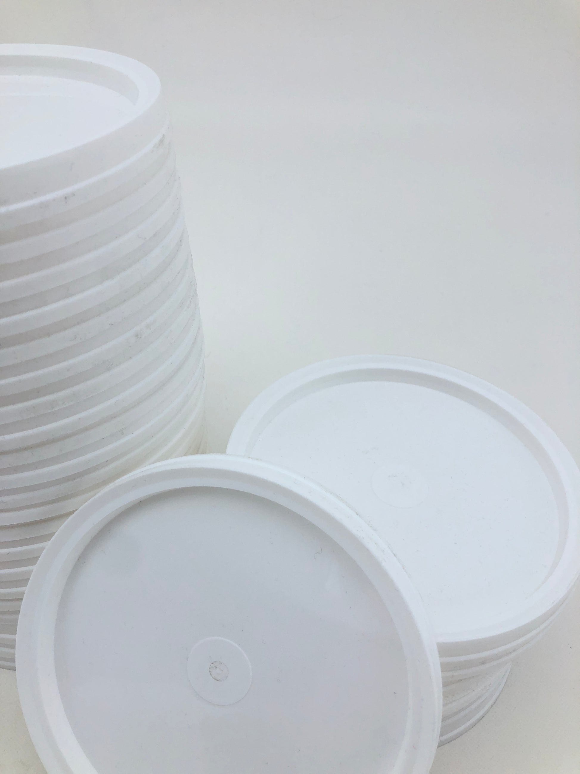 Small white paint palettes are grouped together on a white surface