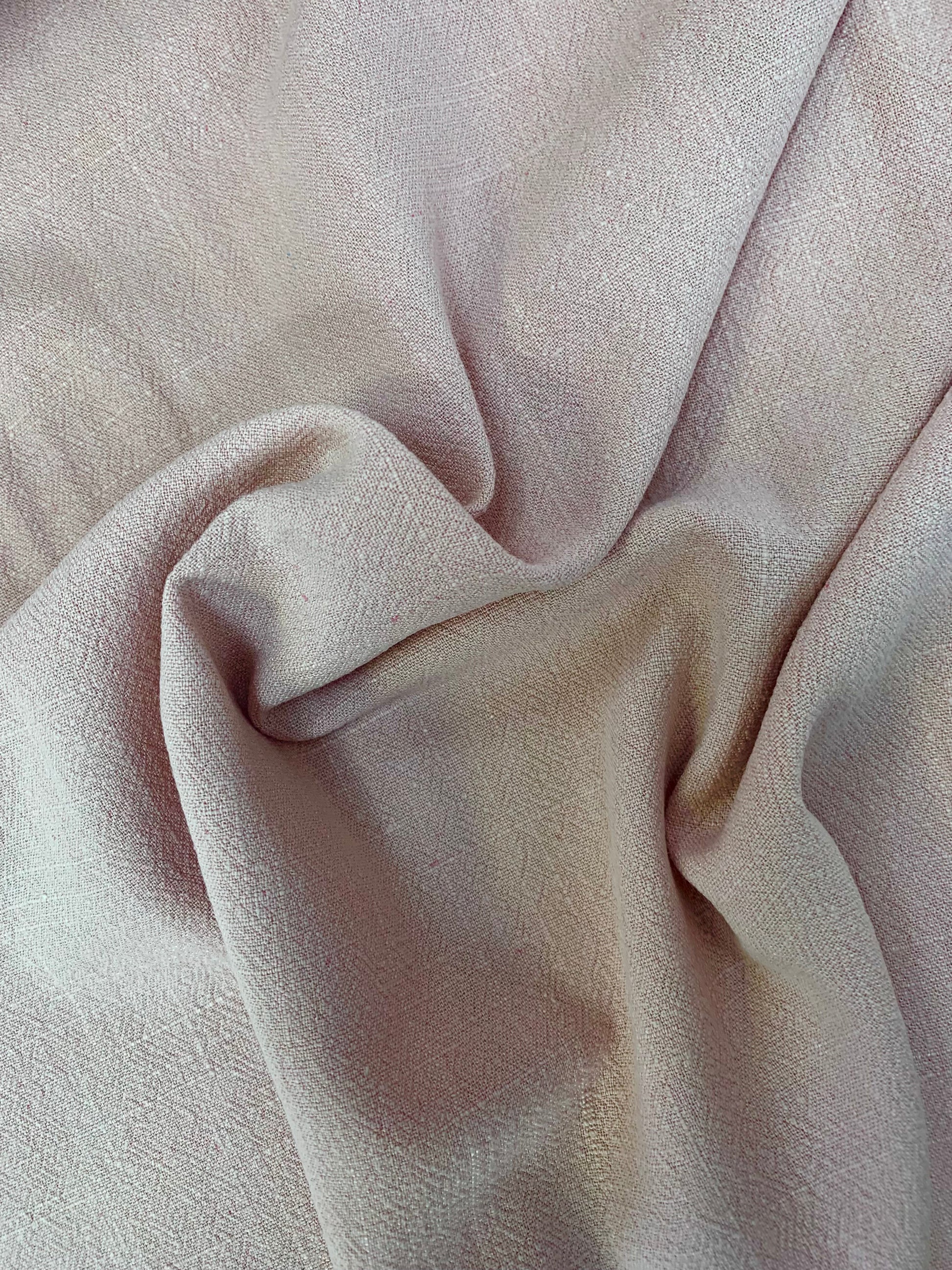 Light sand-coloured fabric is shown close-up with gentle folds
