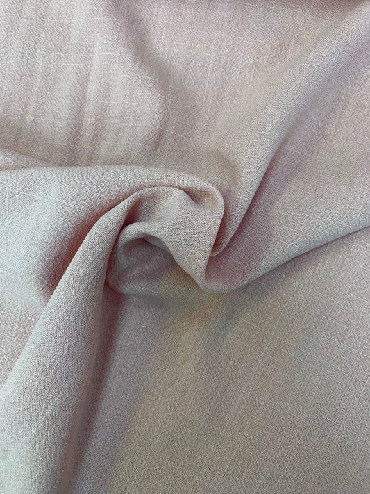 Pale viscose-linen fabric is folded with visible soft texture