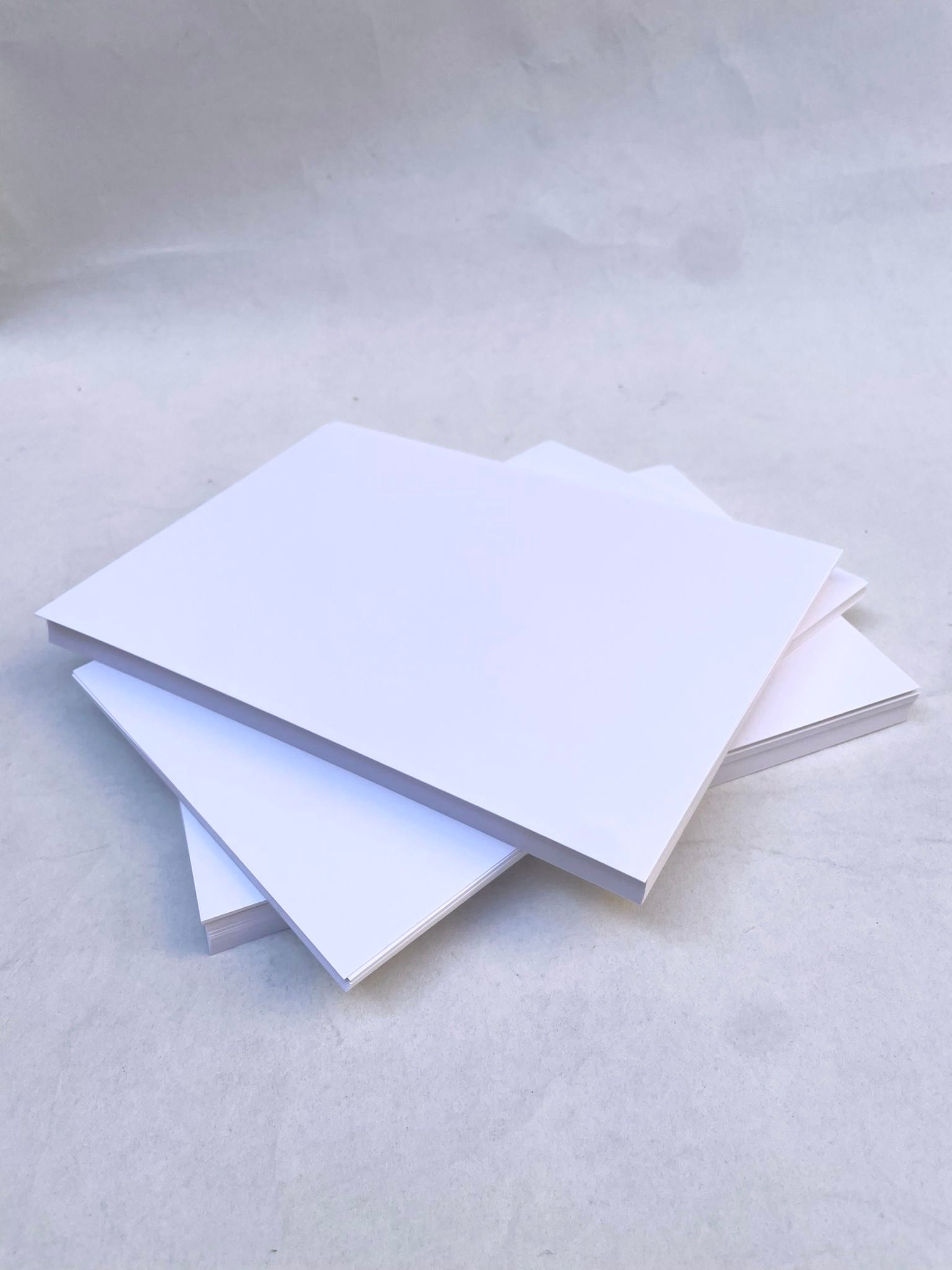 hite paper  are stacked in a neat pile on a white background.
