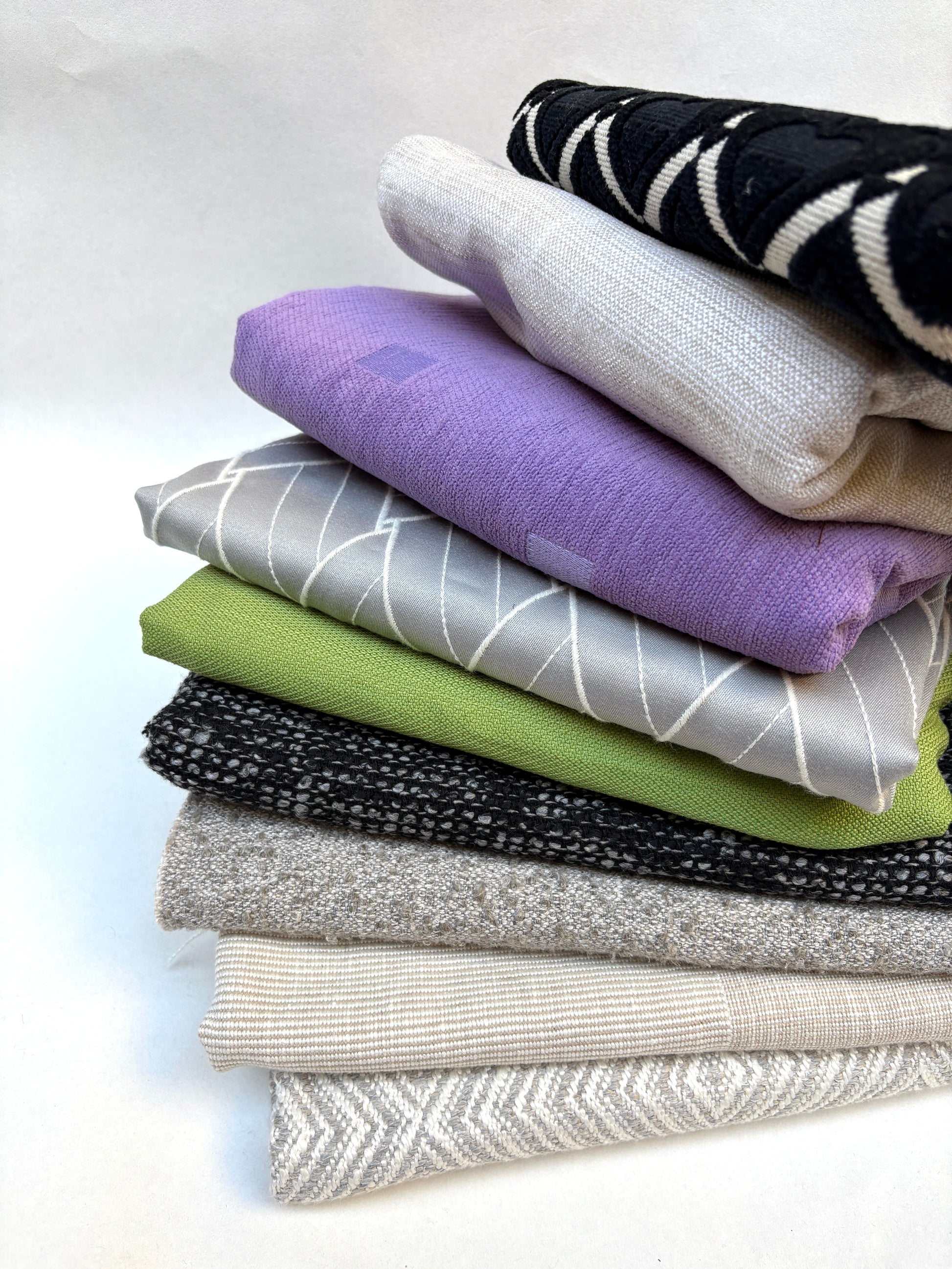 Patterned upholstery fabric medium pieces in a mixed bundle displayed on white.