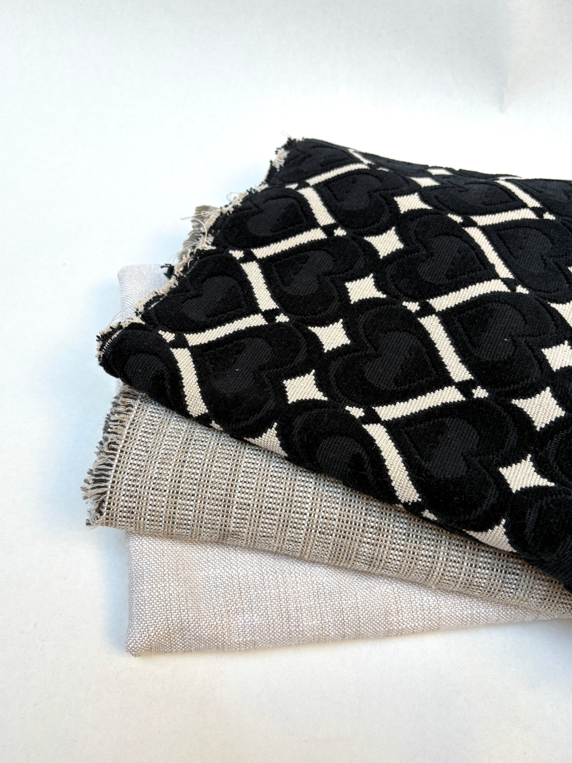 Close-up of mixed patterned upholstery fabric medium pieces on a white background.