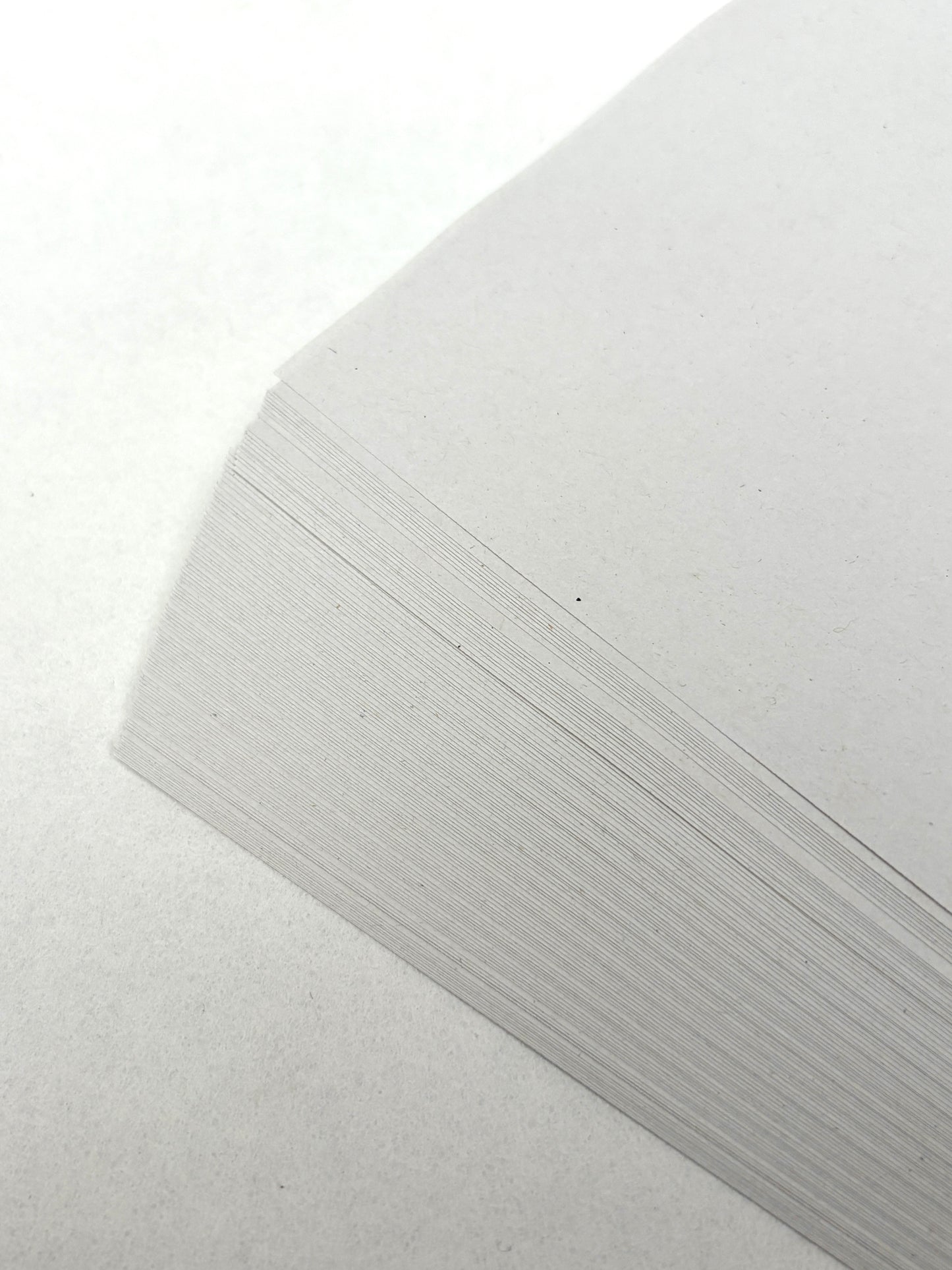 White paper sheets are shown in a close-up stack