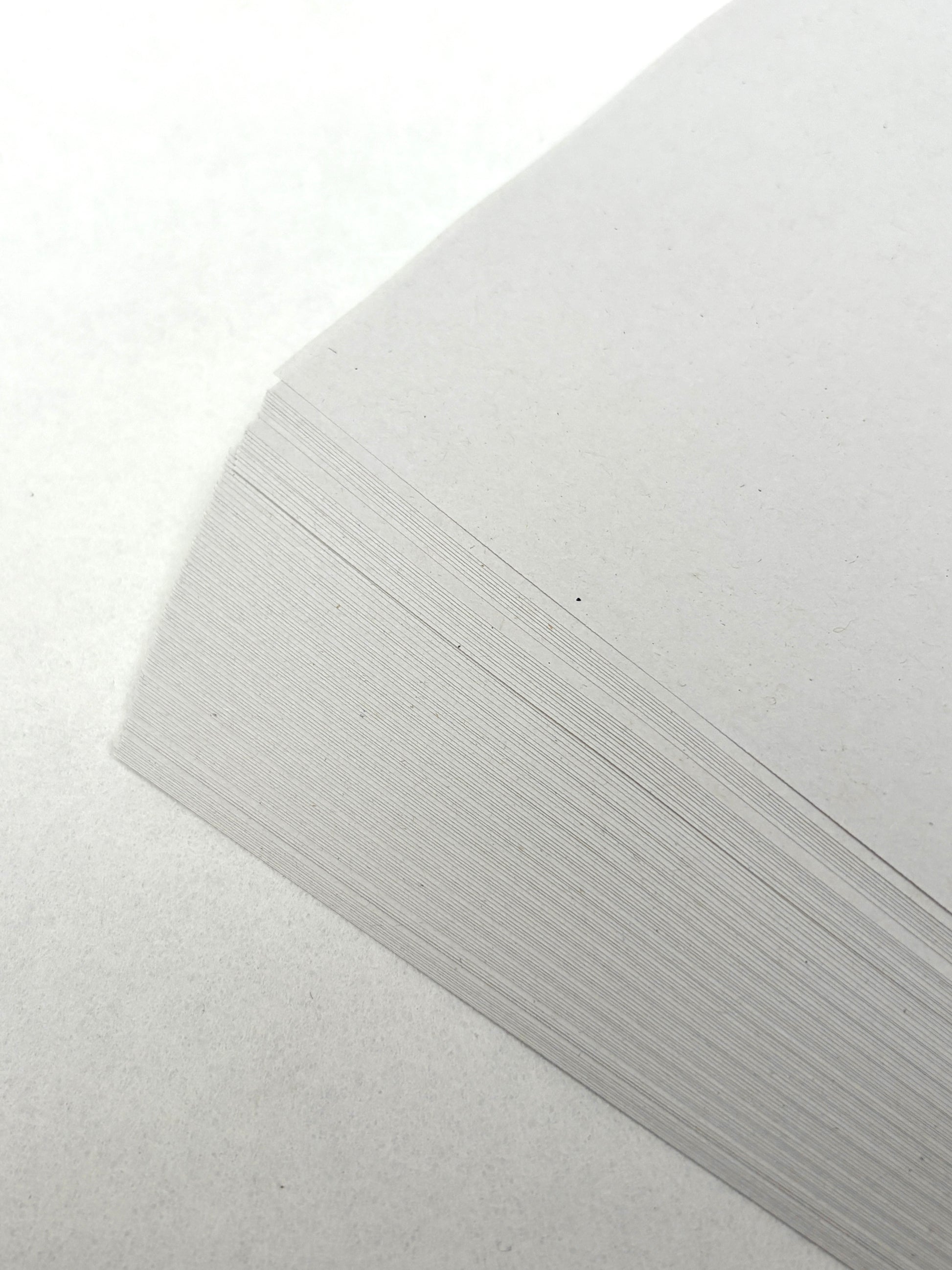 White paper sheets are shown in a close-up stack