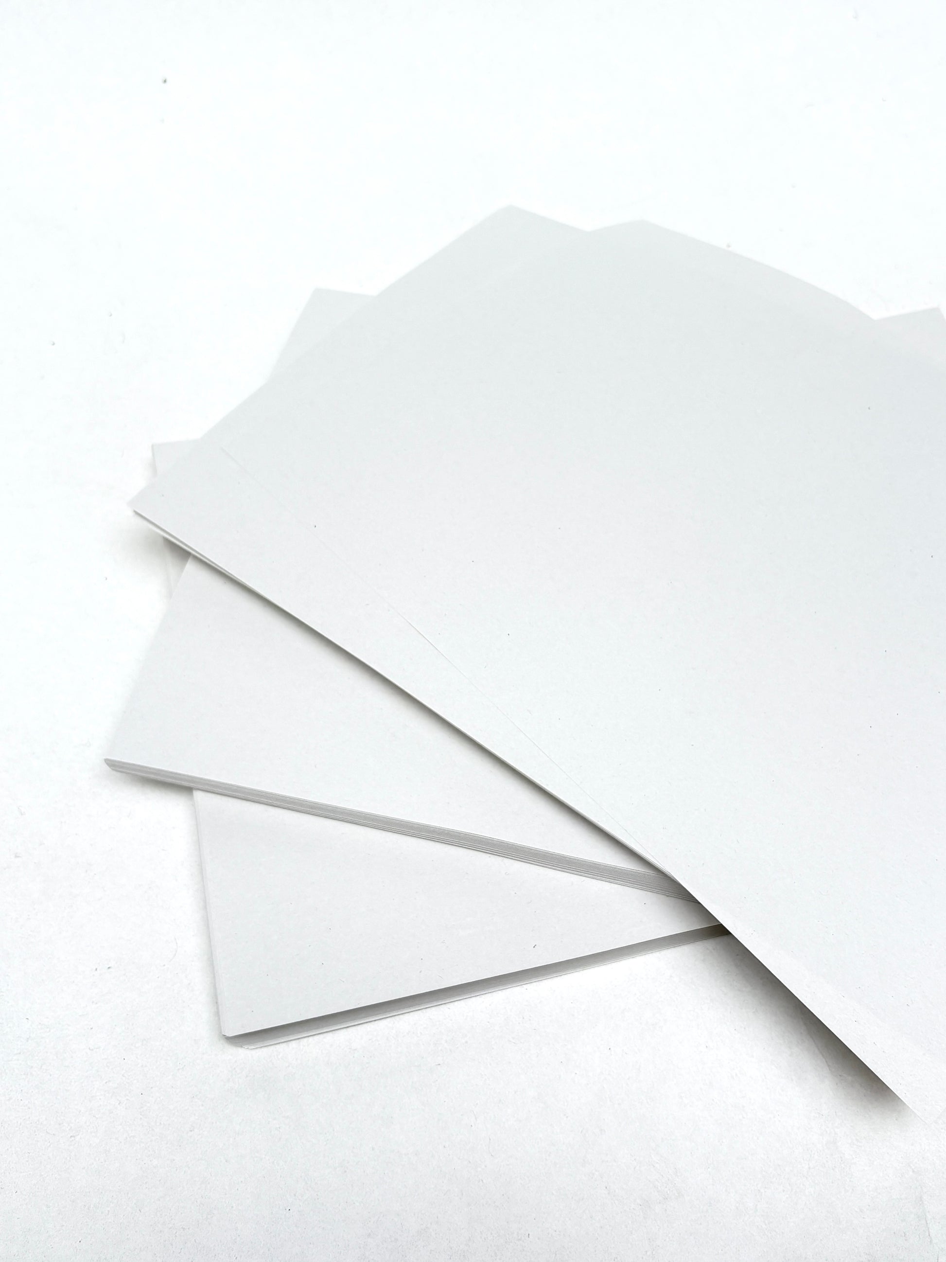 Thin white paper sheets are layered with one page lifted