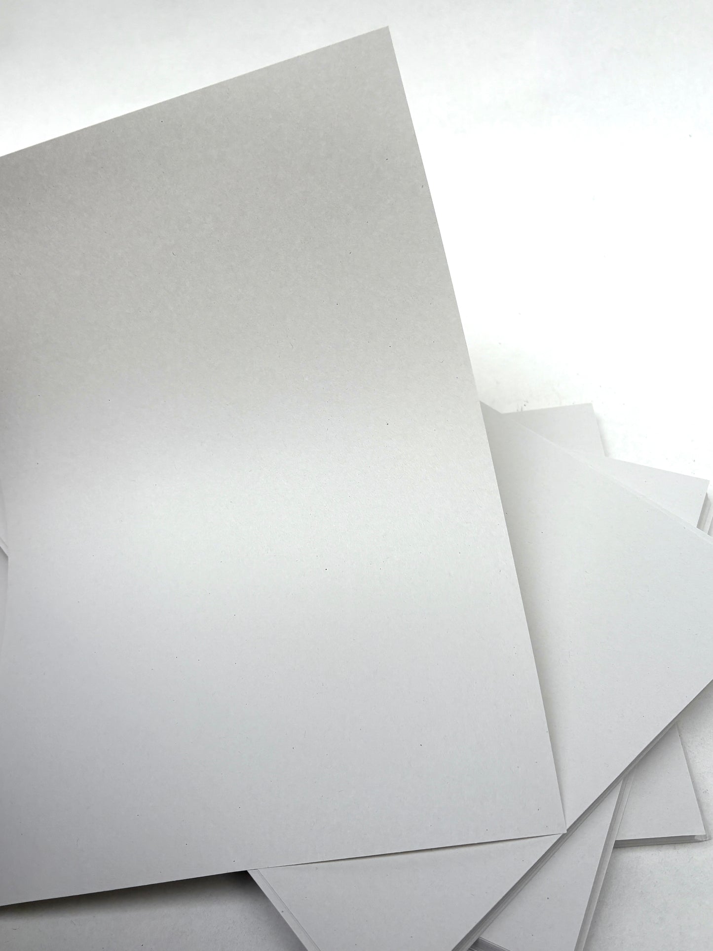 White paper sheets are shown in a close-up stack