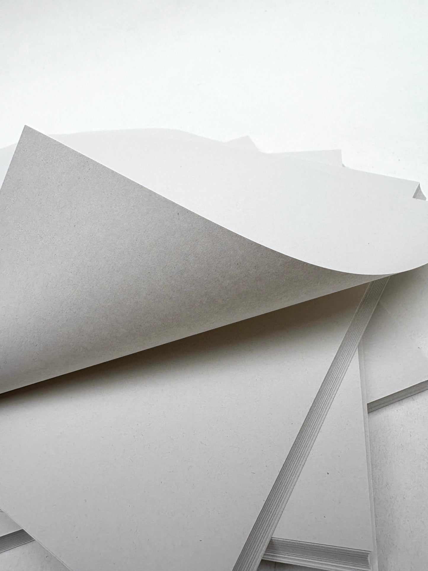 White paper sheets are shown in a close-up stack