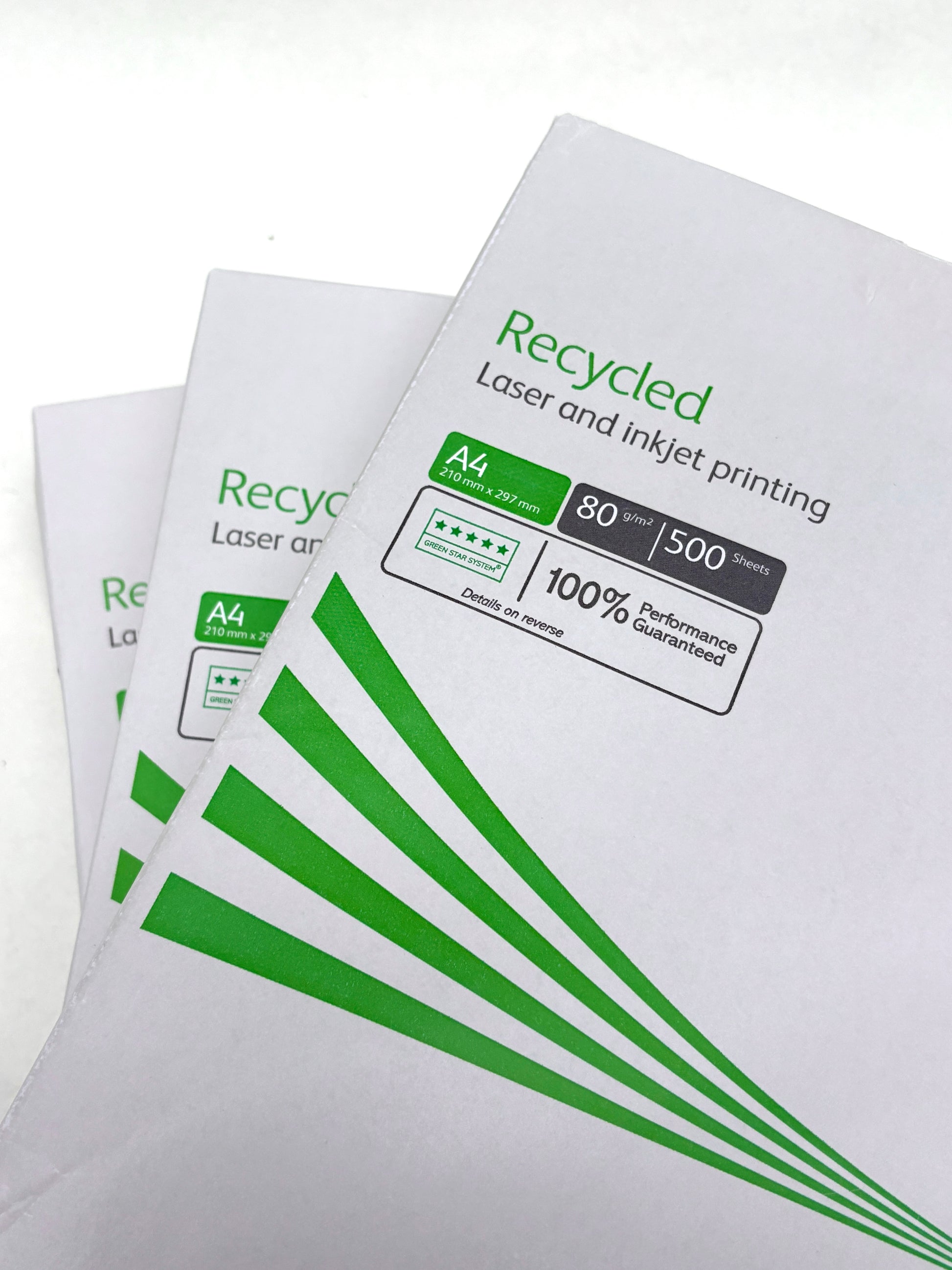 Paper packs with green printed details lie on a white surface
