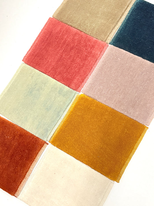 Velvet fabric swatches in assorted colours arranged in a neat grid.