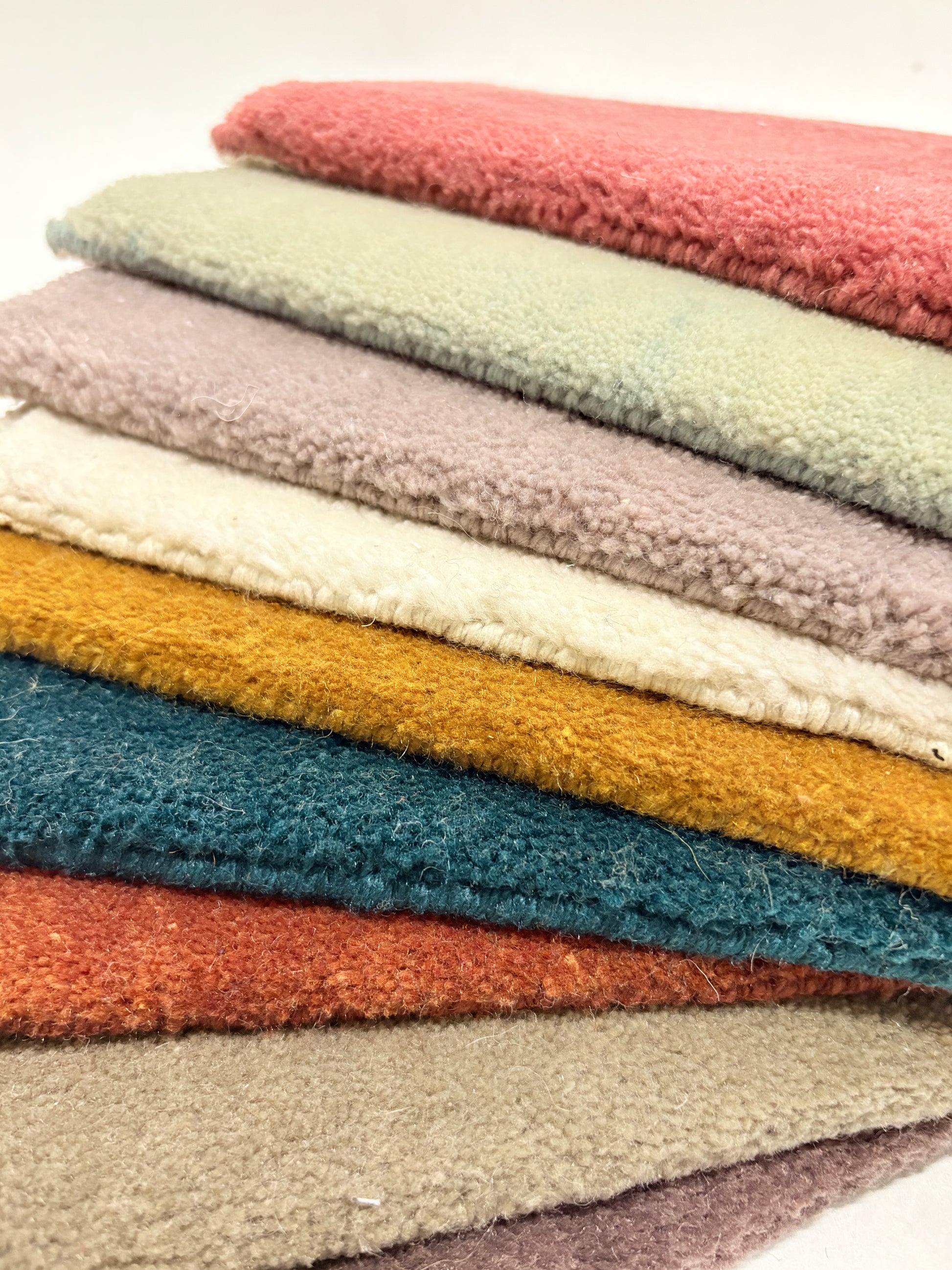 Close-up shots of multi-layered velvet fabric samples in various colors and with a soft, fluffy texture.