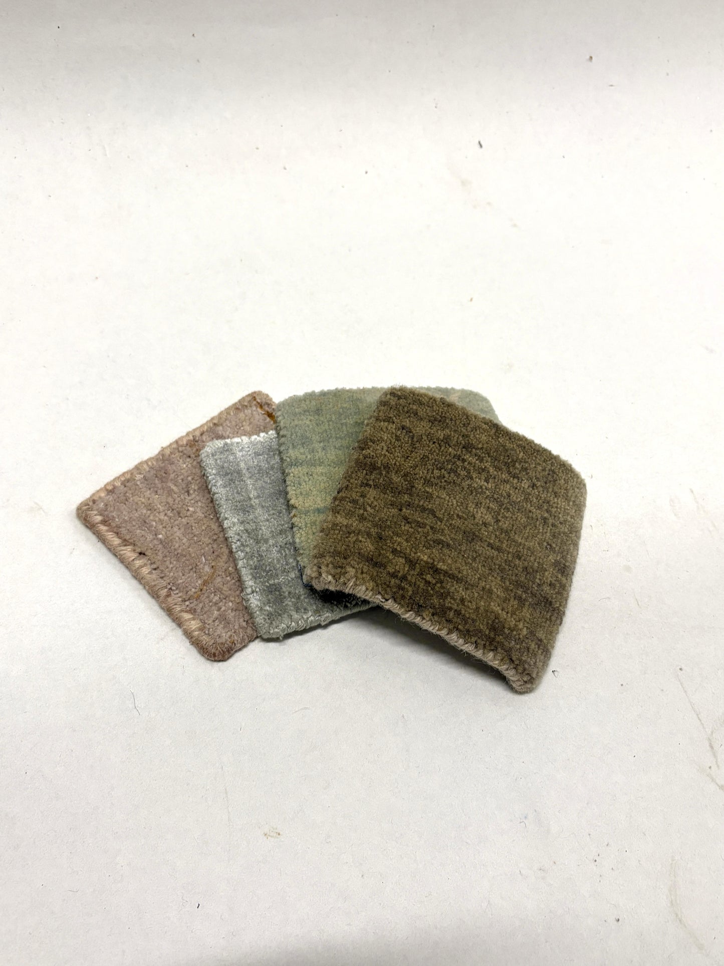 Stacked velvet fabric swatches in muted neutral tones on white.