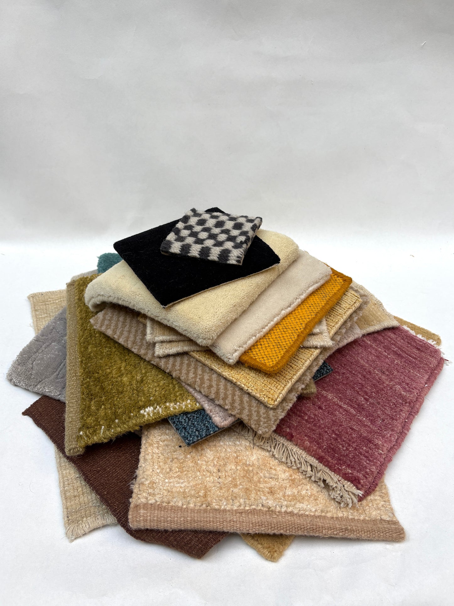 Mixed fabric and surface samples are stacked on a white background