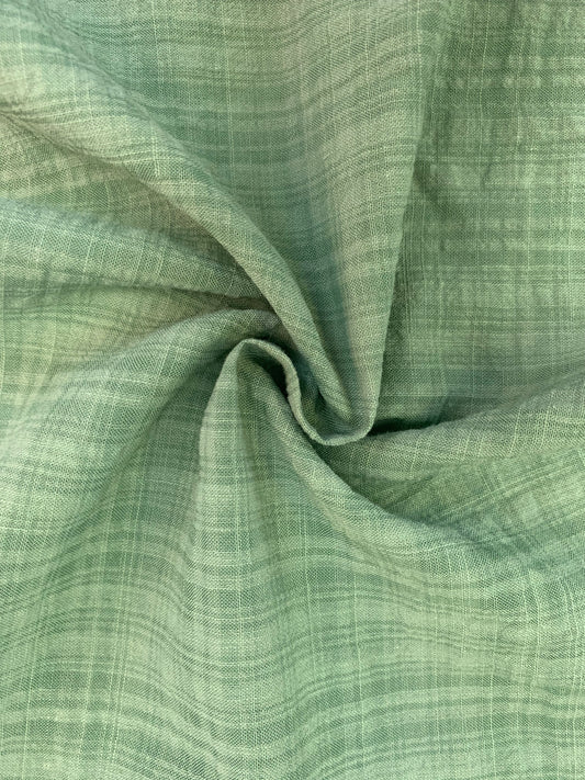 A detailed shot of sage green check fabric with a softly crinkled look.