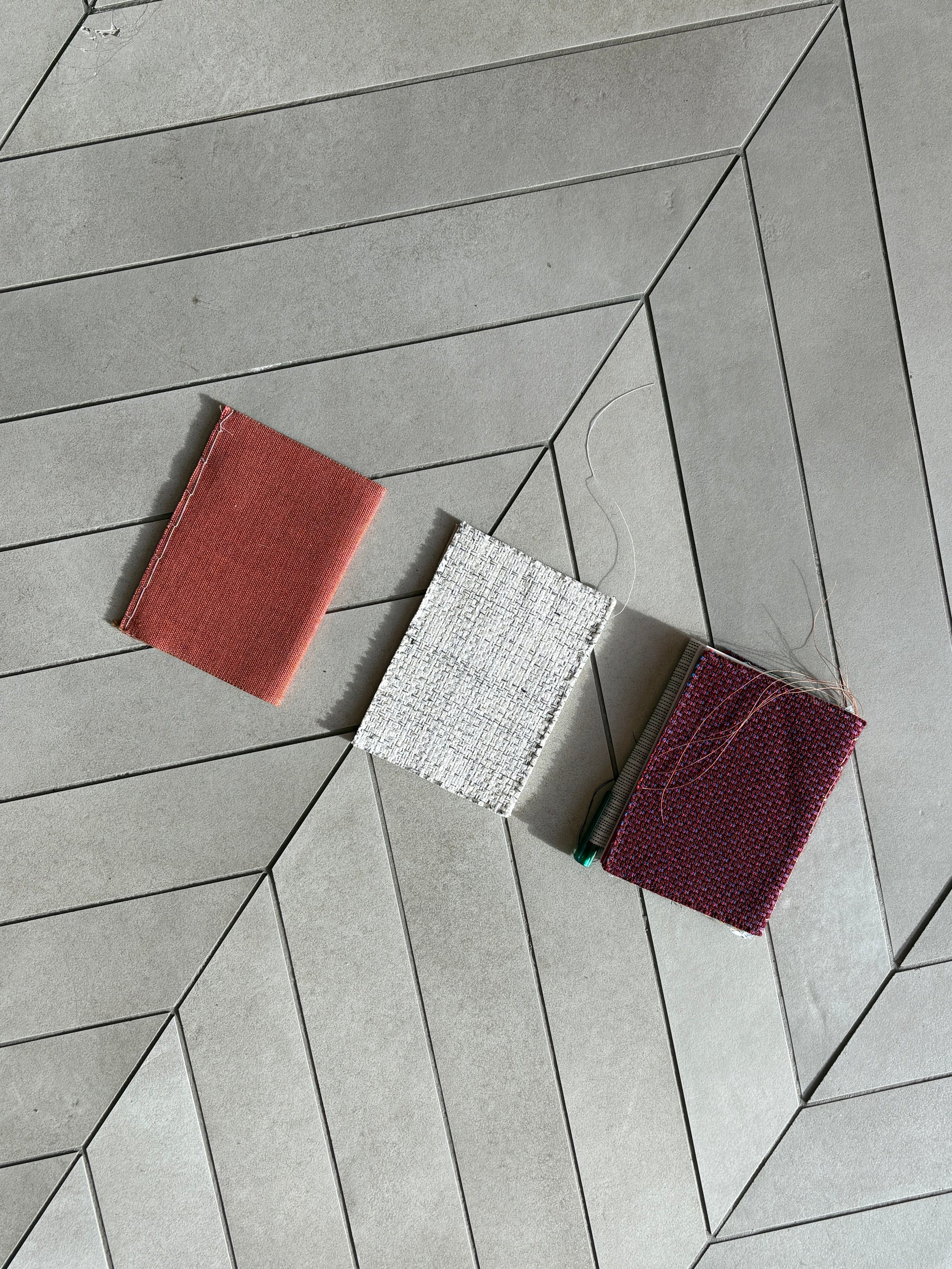 Flat lay of three fabric swatches on a geometric cardboard background.
