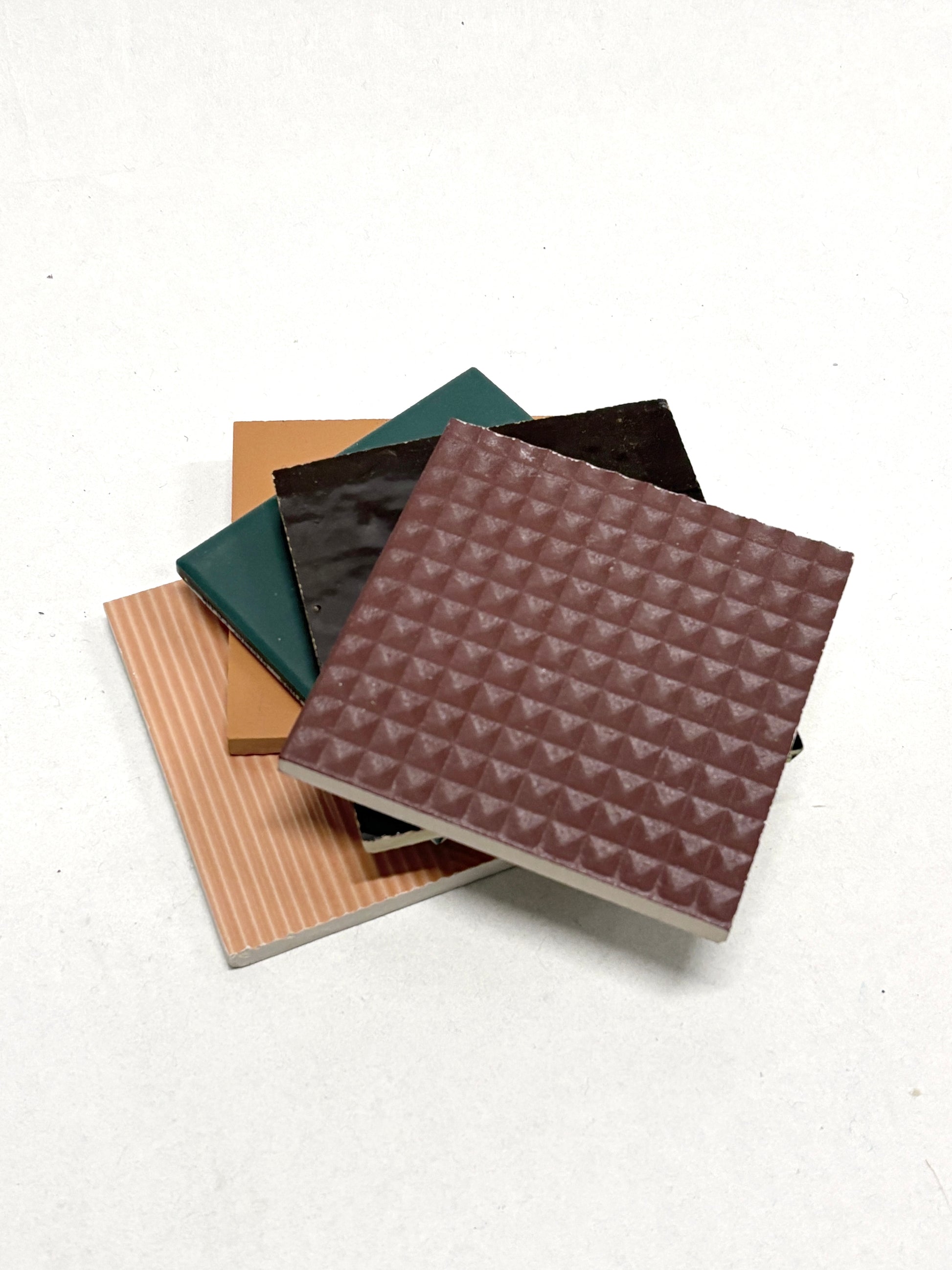 Stacked sample tiles are shown in detail with smooth glossy finishes