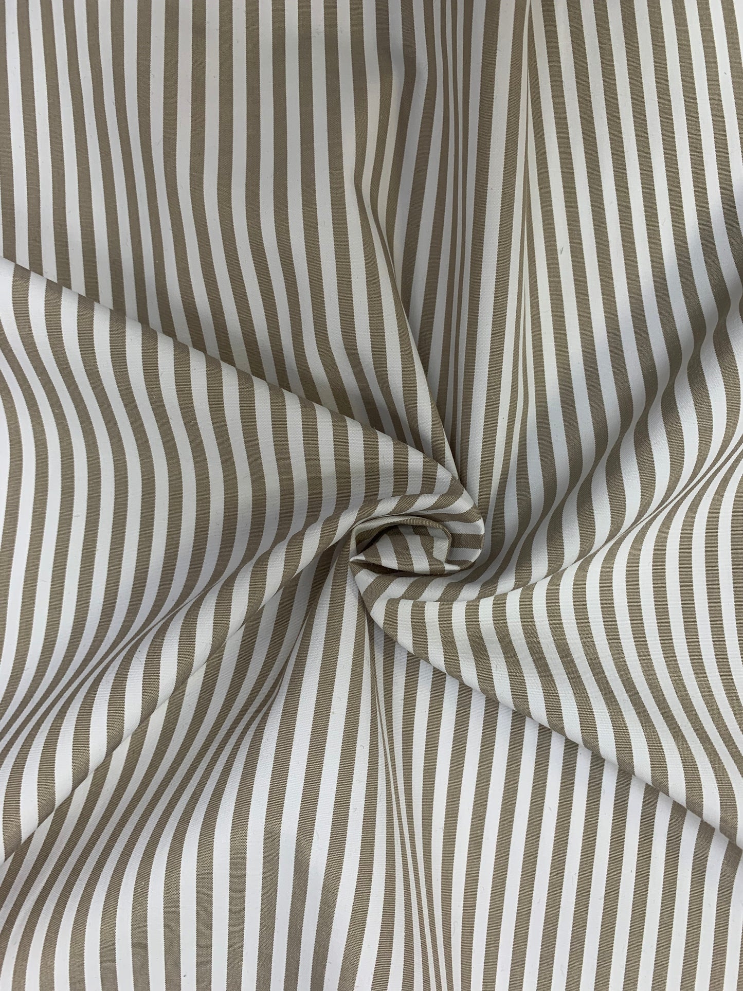 Close detail of stone-white stripe shirting gathered in gentle folds.