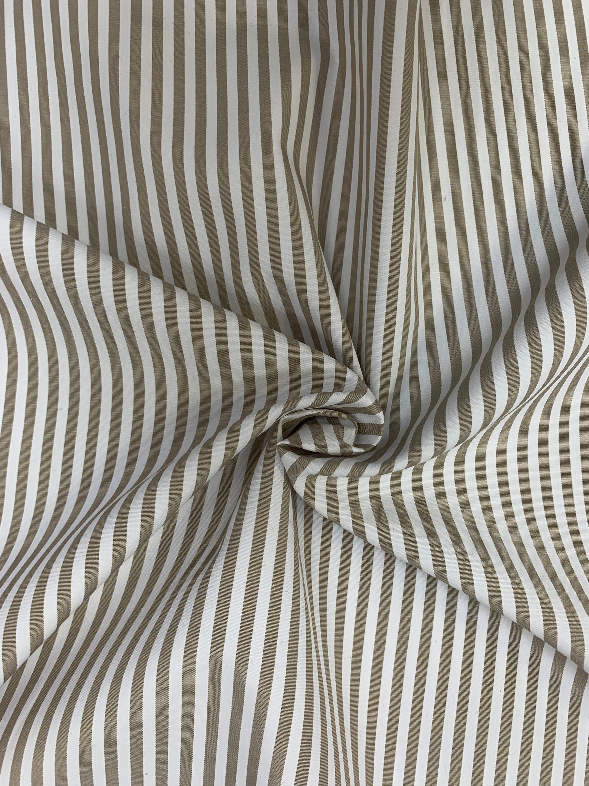 Close detail of stone-white stripe shirting gathered in gentle folds.