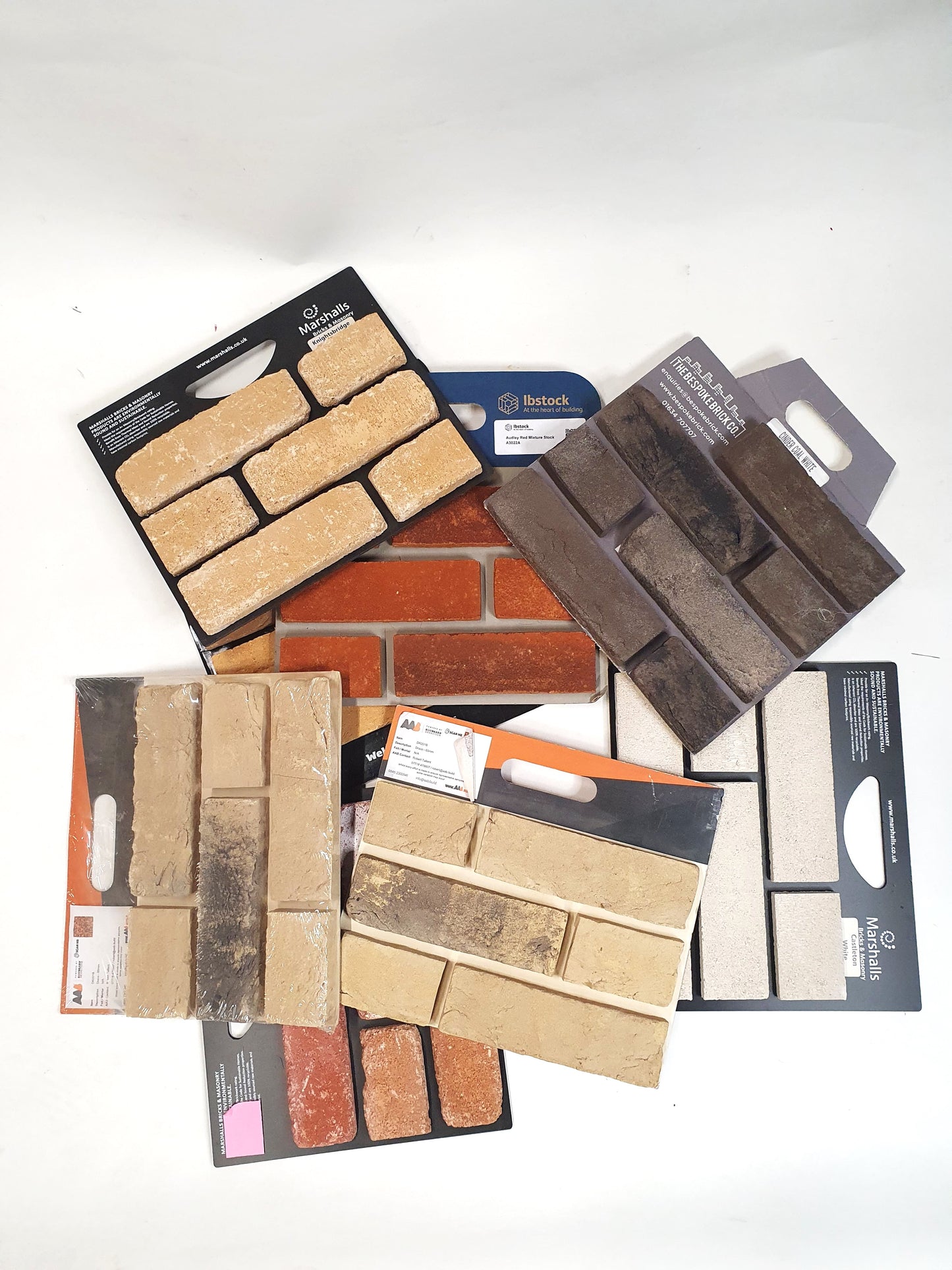 Flat lay of assorted brick sample boards arranged on a white background.