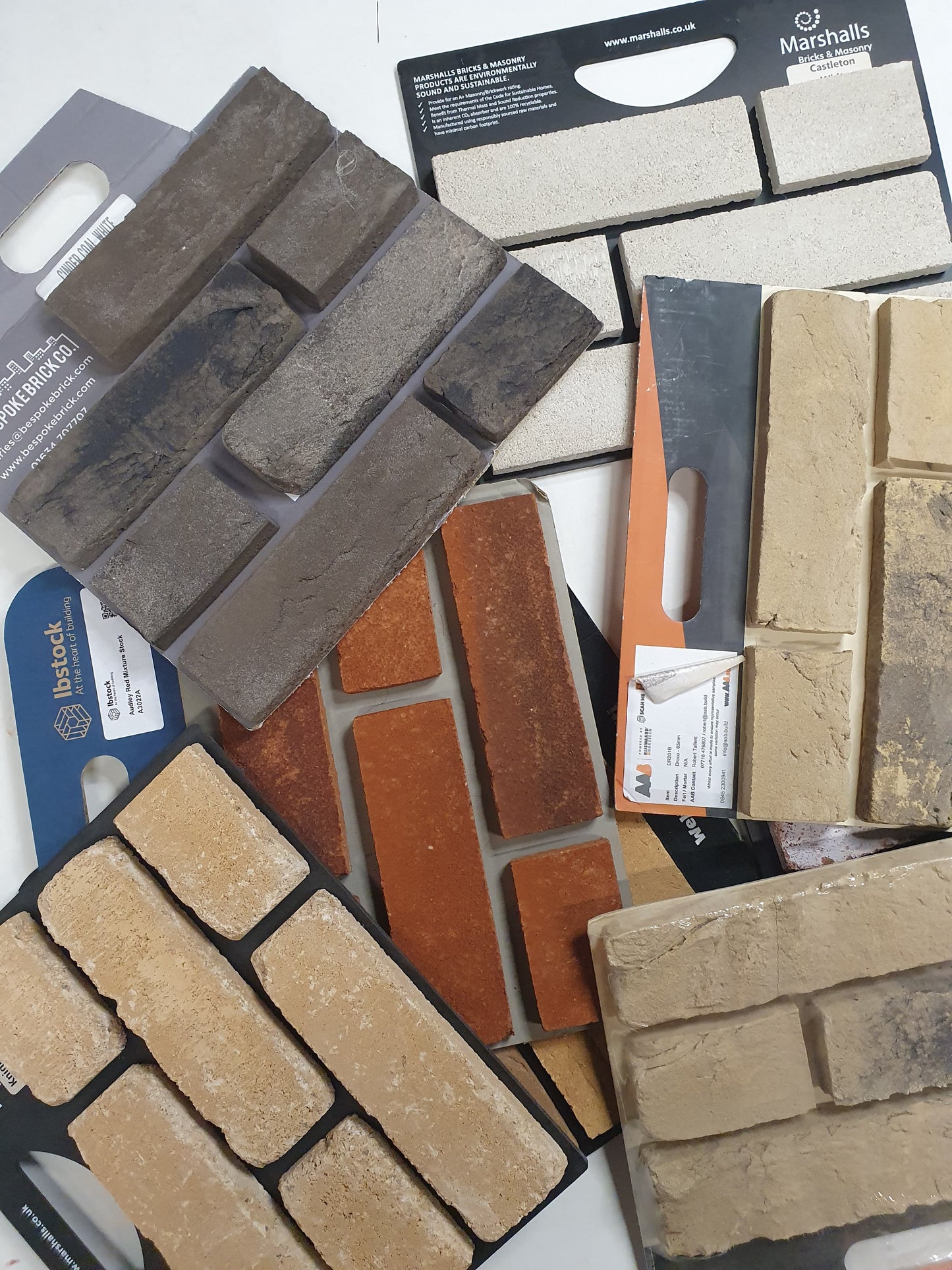Close-up of assorted brick sample boards layered on a white background.