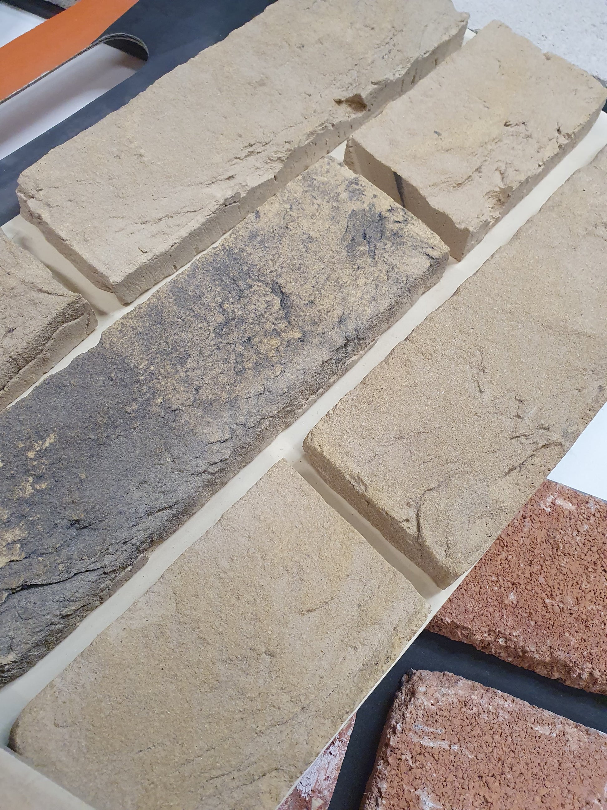 Close-up of textured brick samples in natural stone and clay tones.