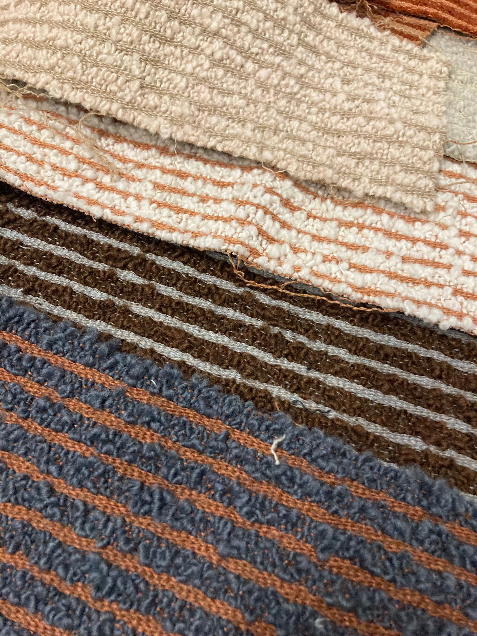 Rolled and flat fabric samples display varied textures and stripe patterns
