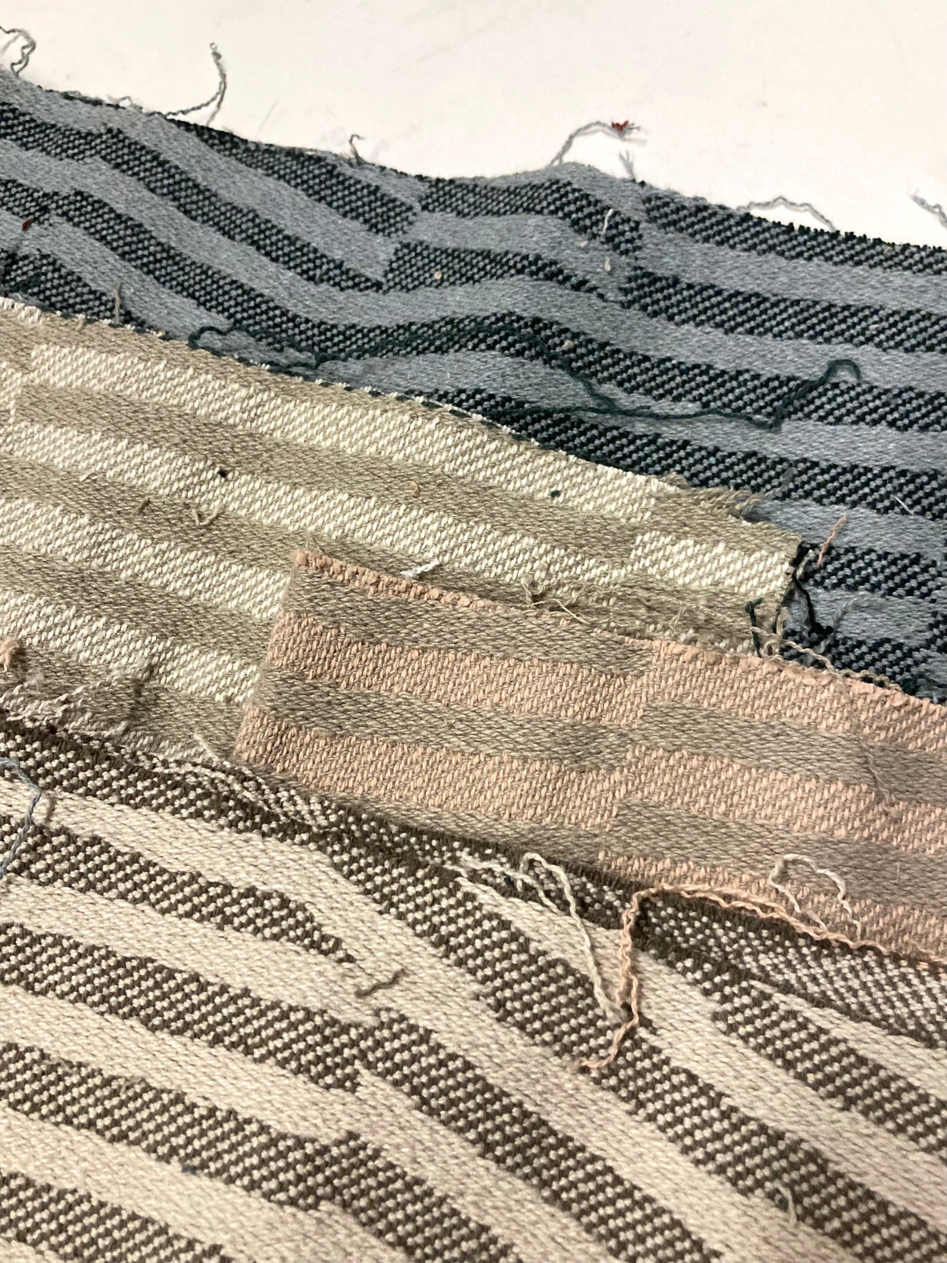 Close-up view shows striped offcuts with frayed woven edges