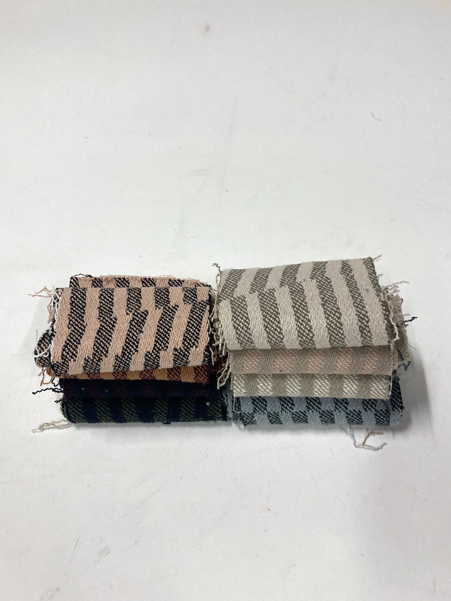 Mixed heavyweight striped fabric pieces are shown in folded layers