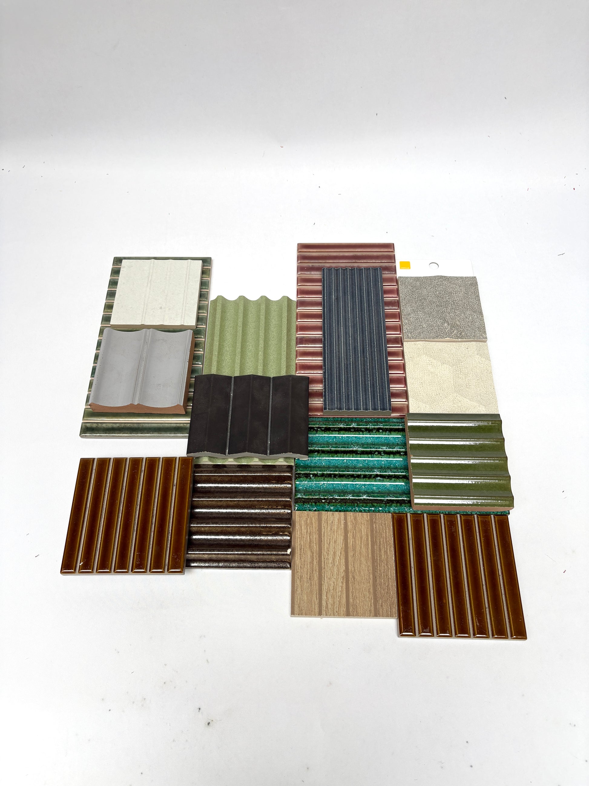 Variety of mixed textured tile pieces arranged on a plain white background.