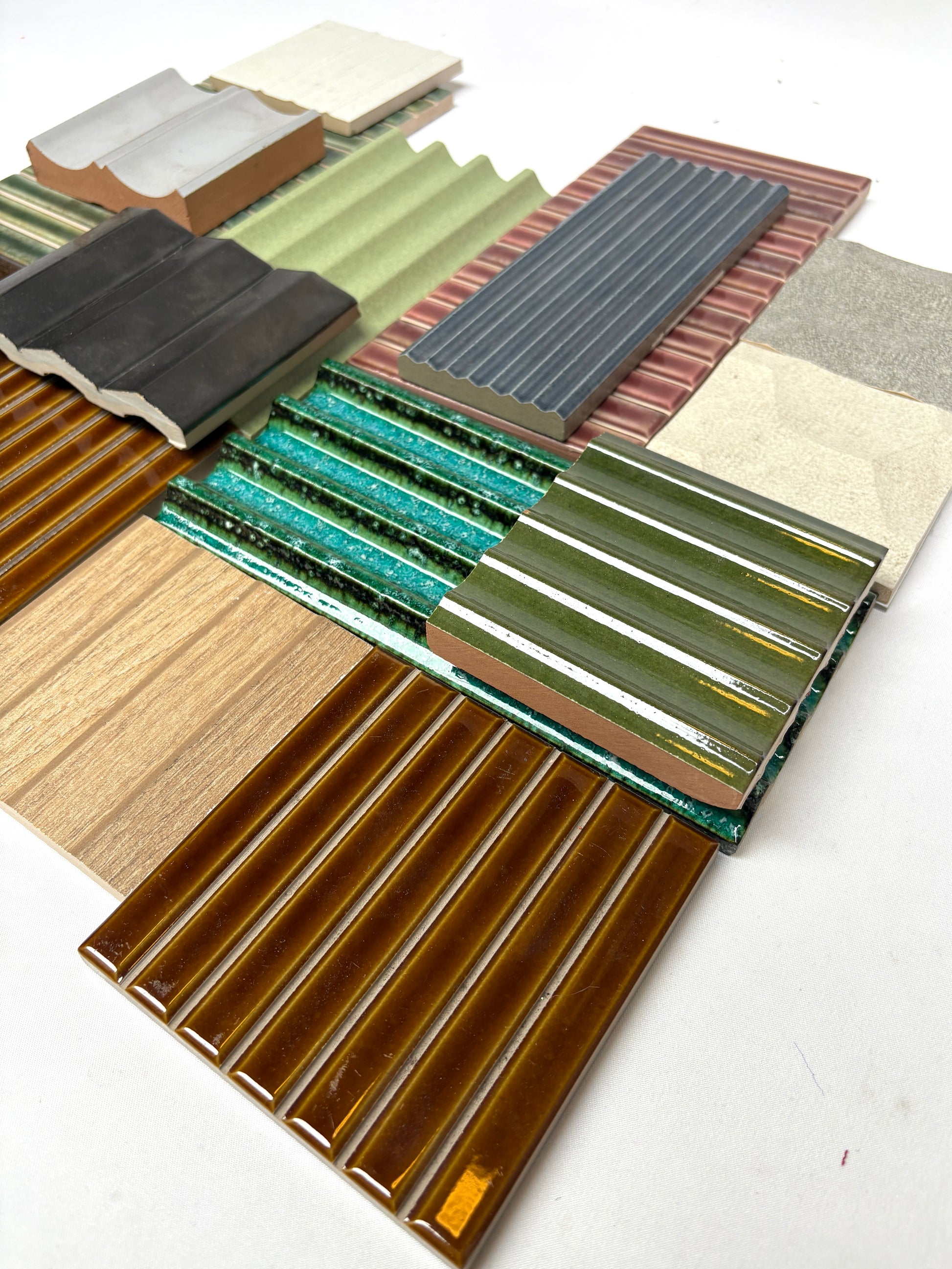 Mixed textured tile samples arranged neatly on a white background.