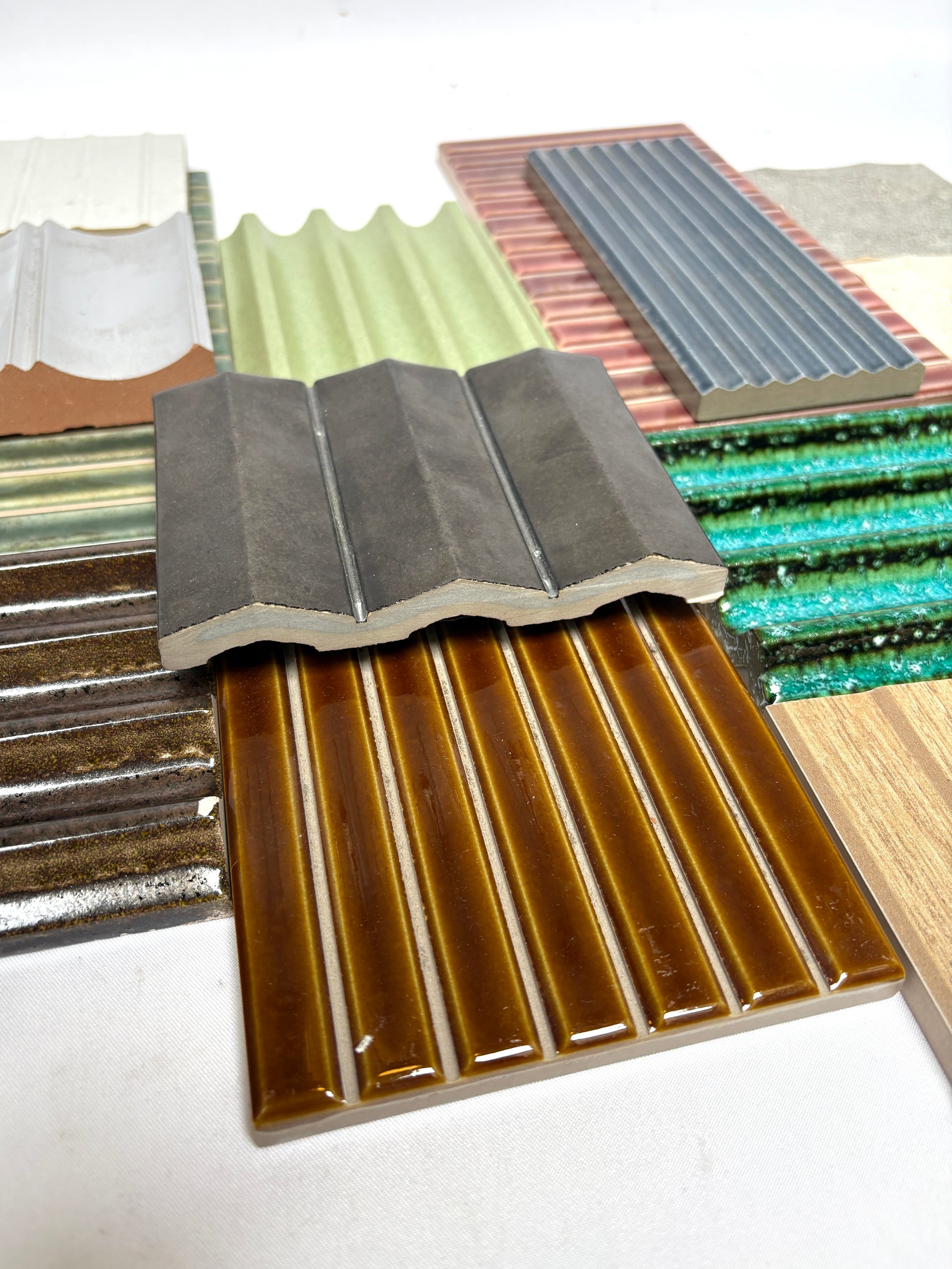Assorted textured tile samples arranged together on a white background.
