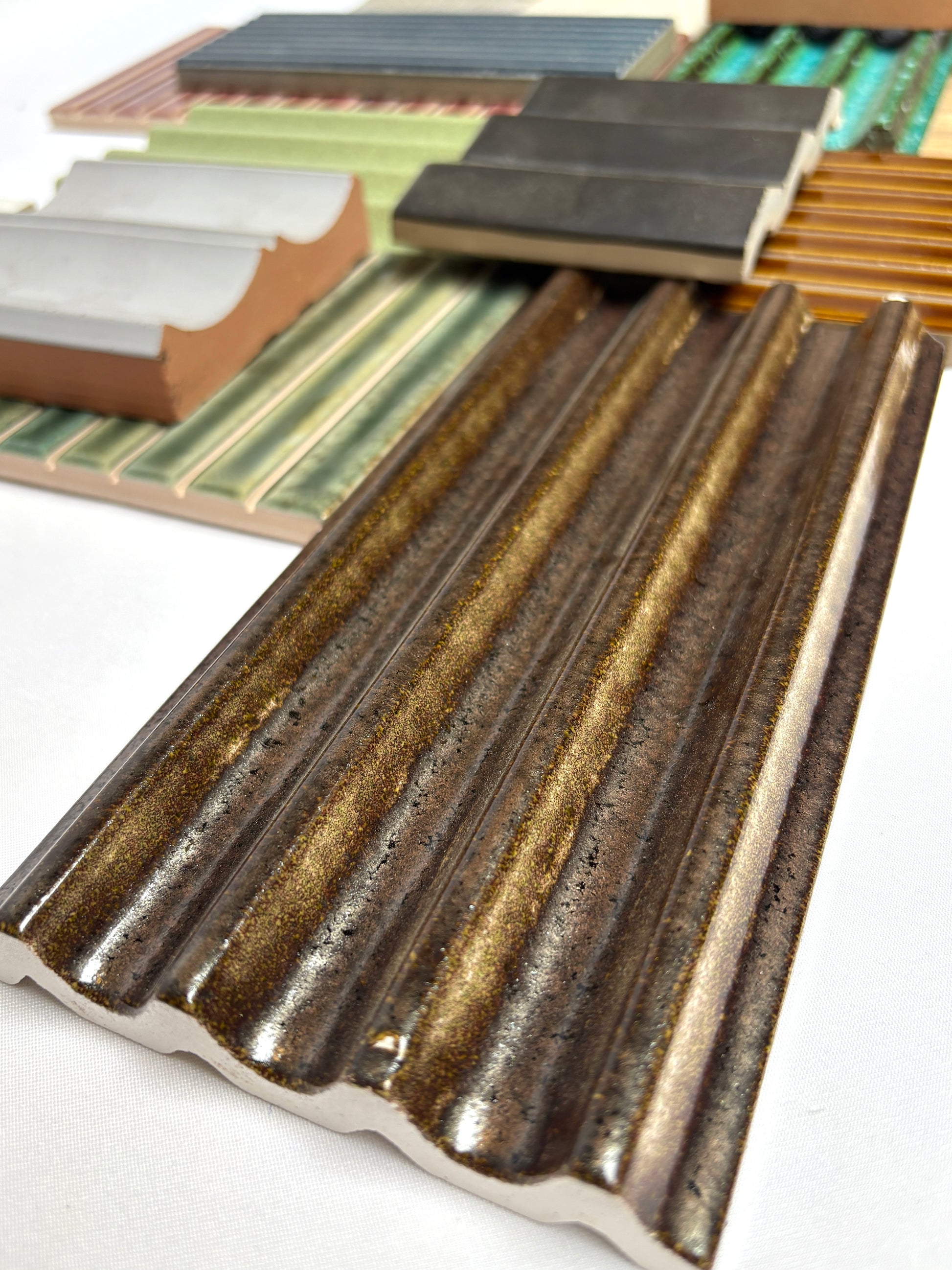 Mixed bundle of decorative textured tiles displayed on a white background.