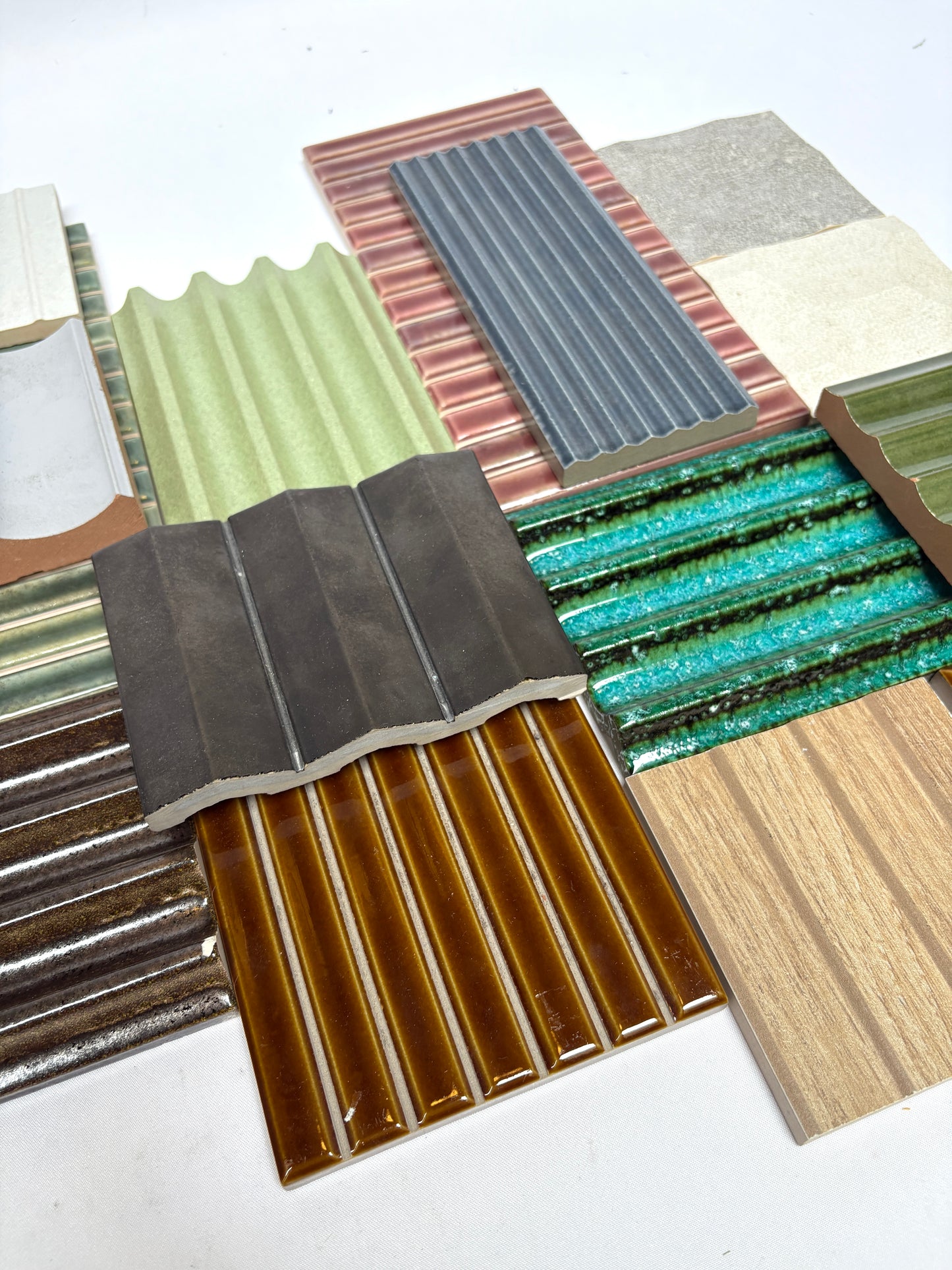Collection of textured tiles in assorted colours and finishes on white.