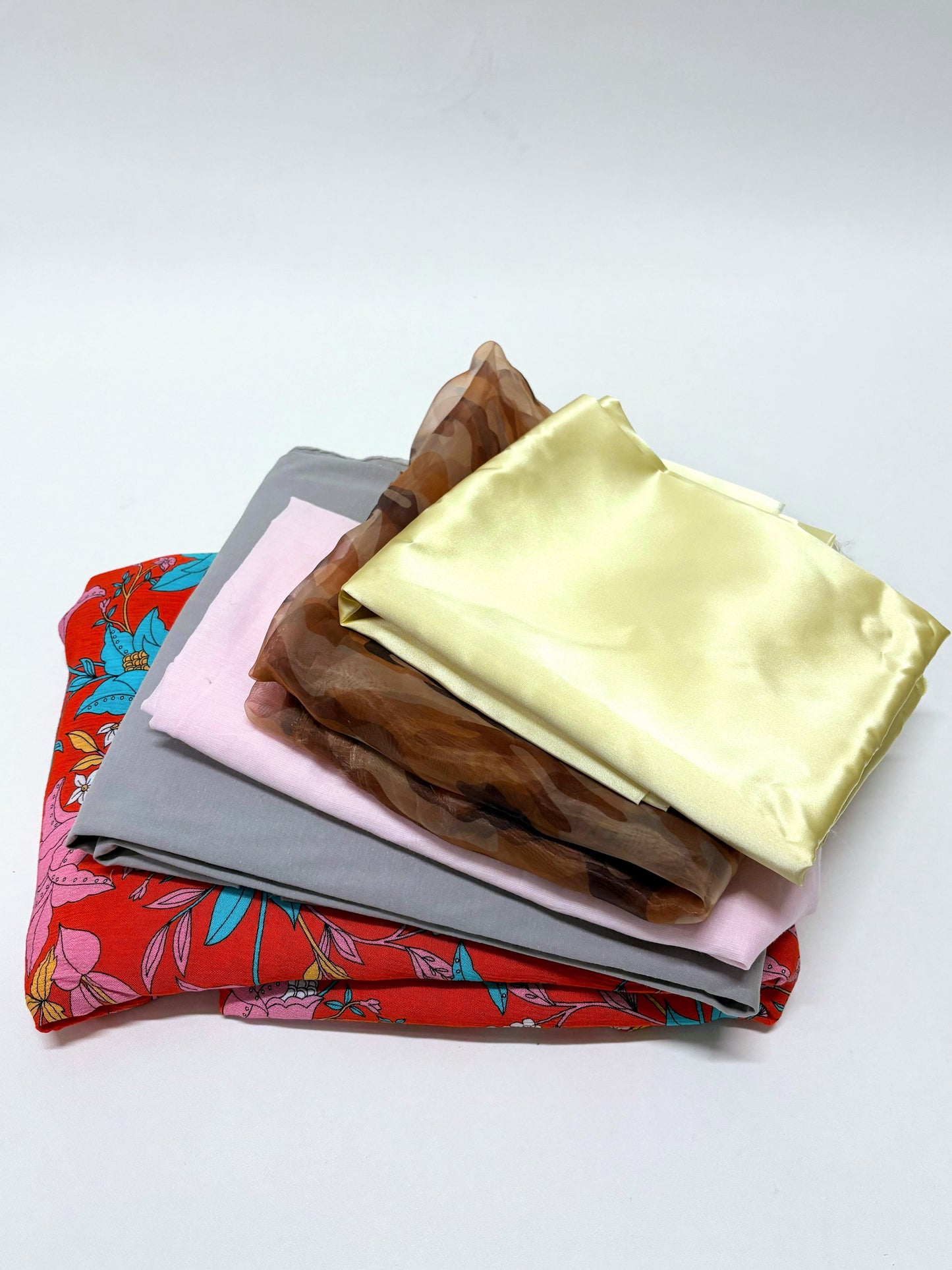 Mixed fabric squares are layered in a small stacked bundle