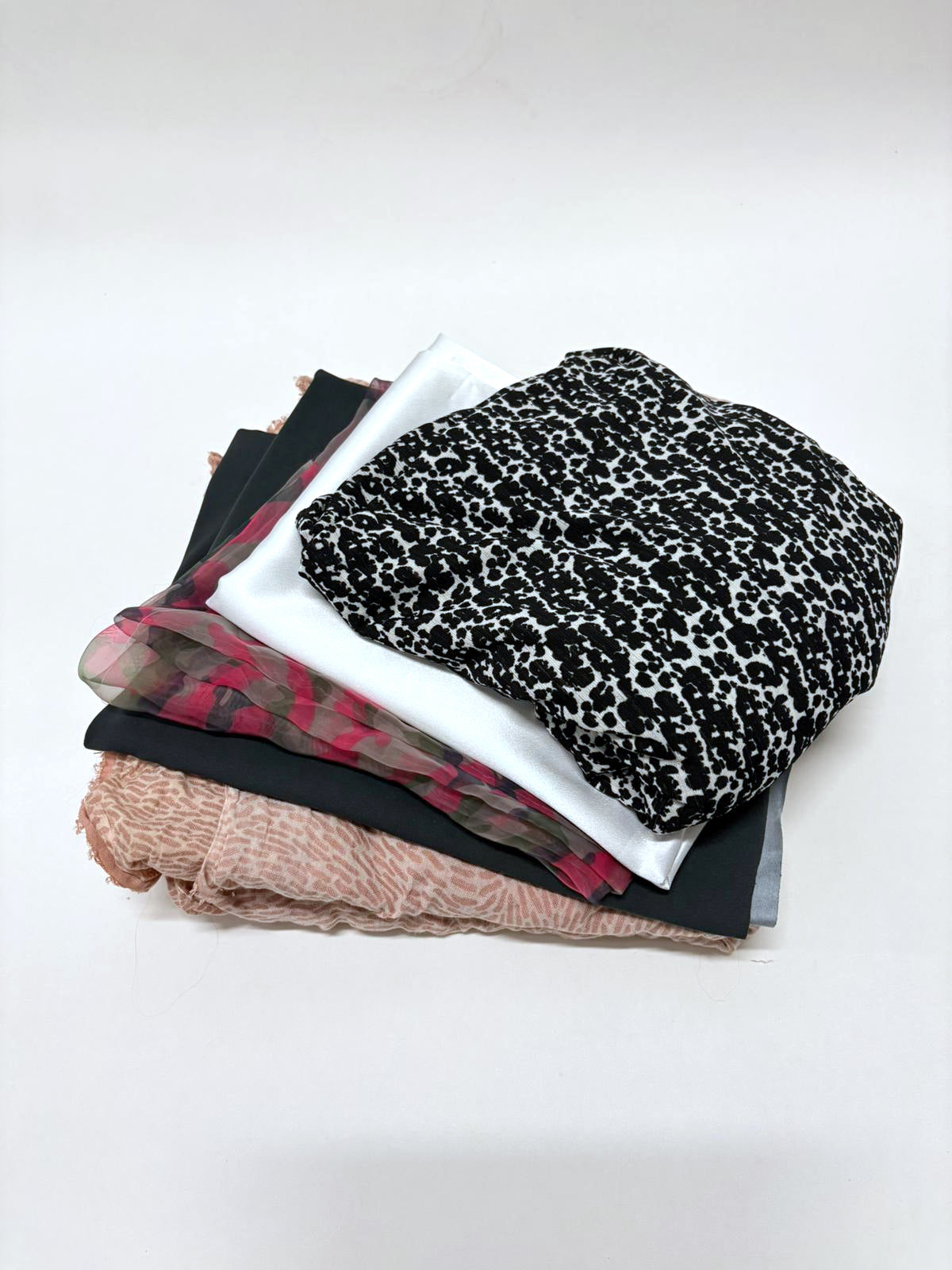 Folded fabrics are stacked in detail with striped and checked patterns