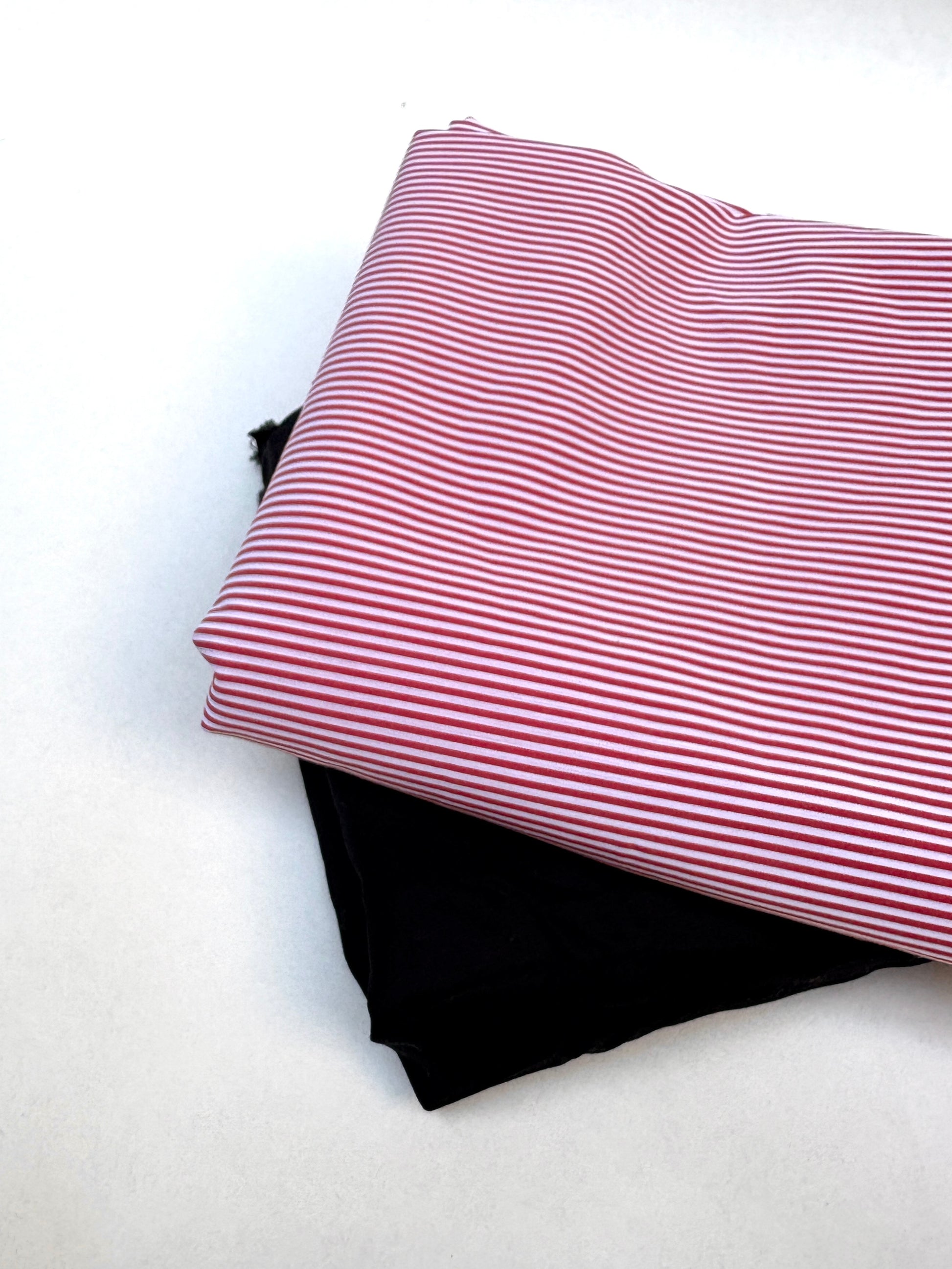 black and red fabric samples are layered in a neat stack