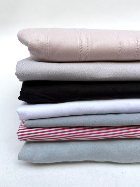 Folded fabric pieces in mixed colours are shown together