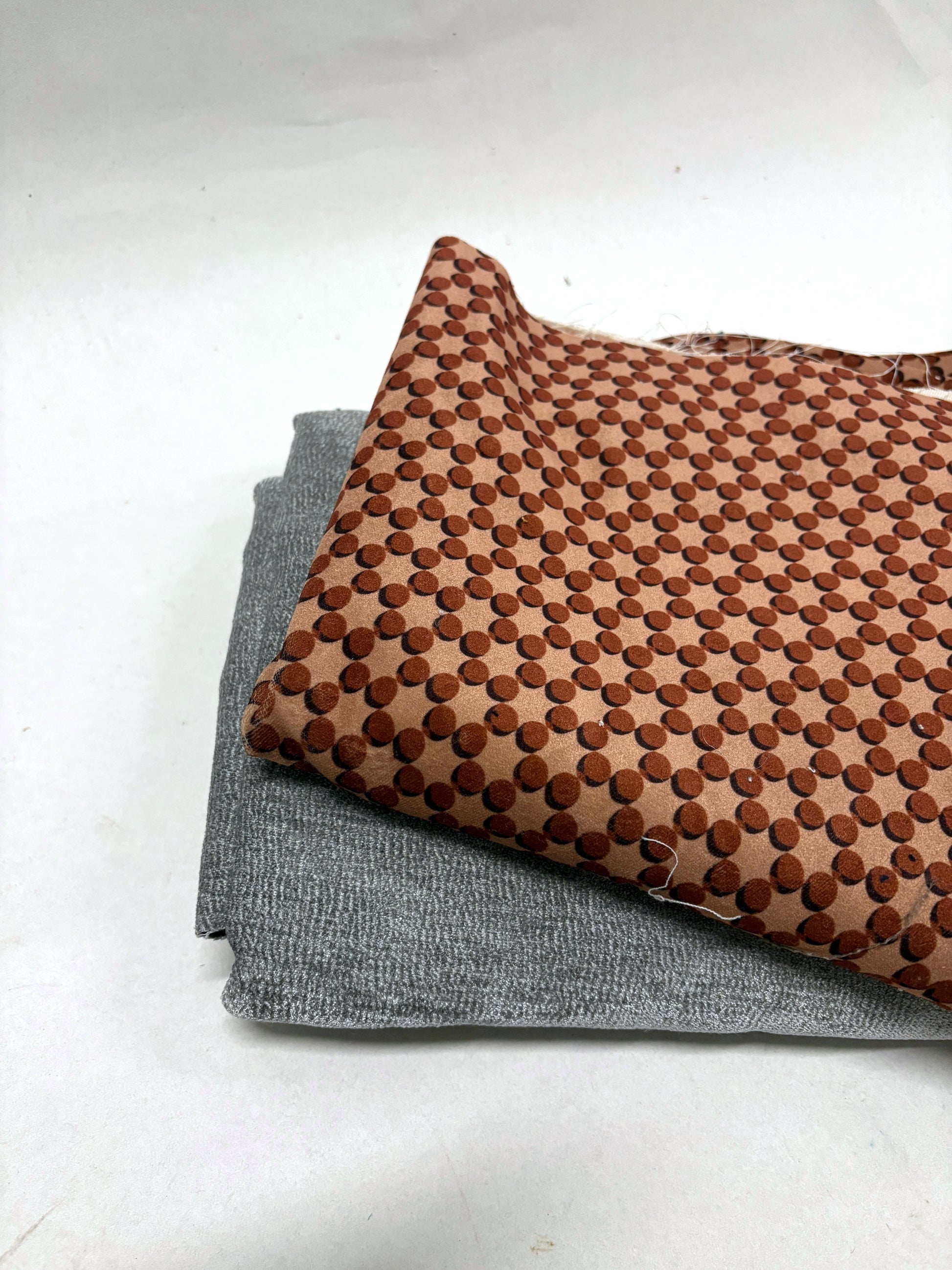 Patterned and plain velvet fabrics are shown in folded stacks