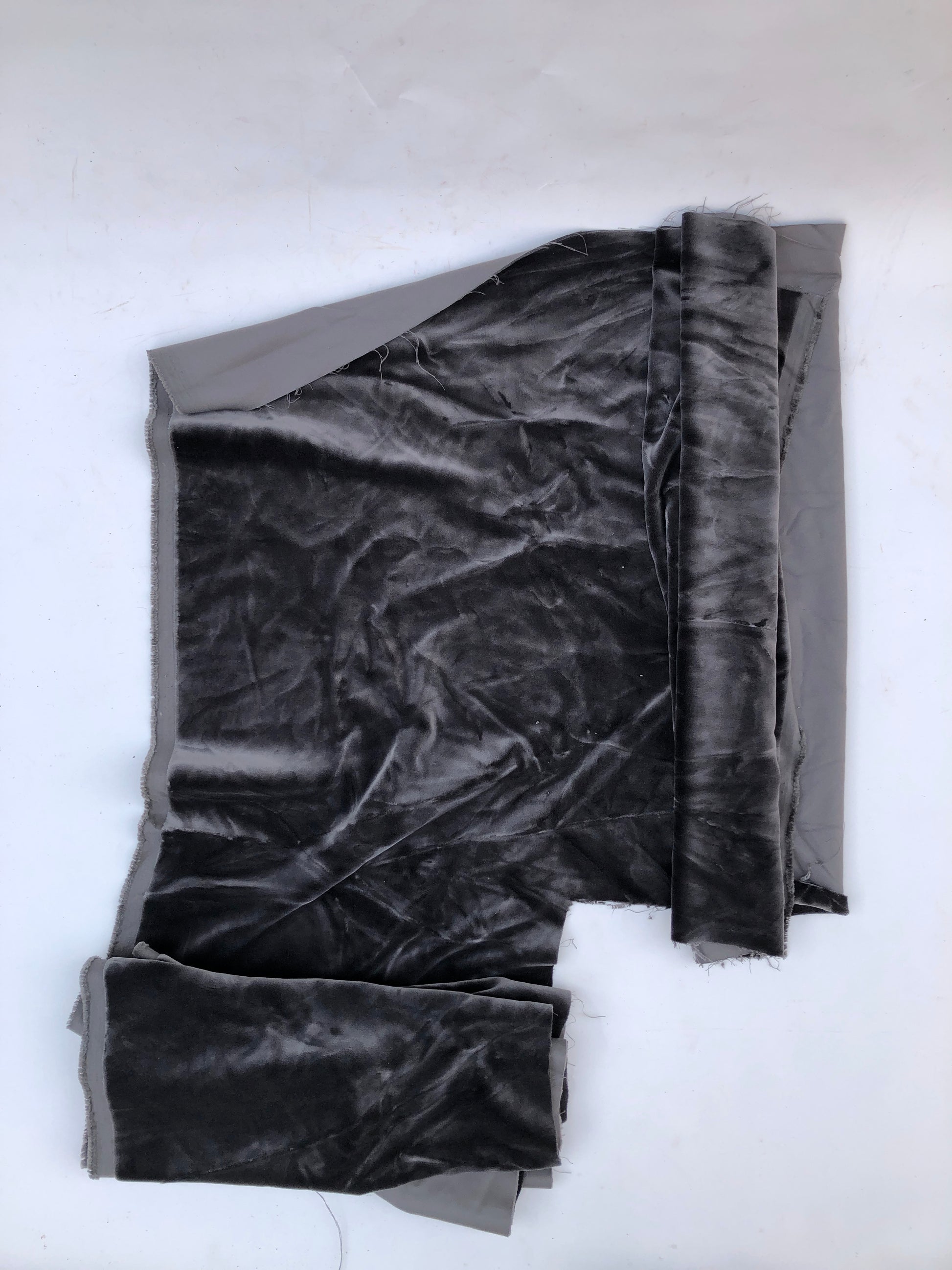 Dark velvet fabric pieces are laid flat in a close-up view