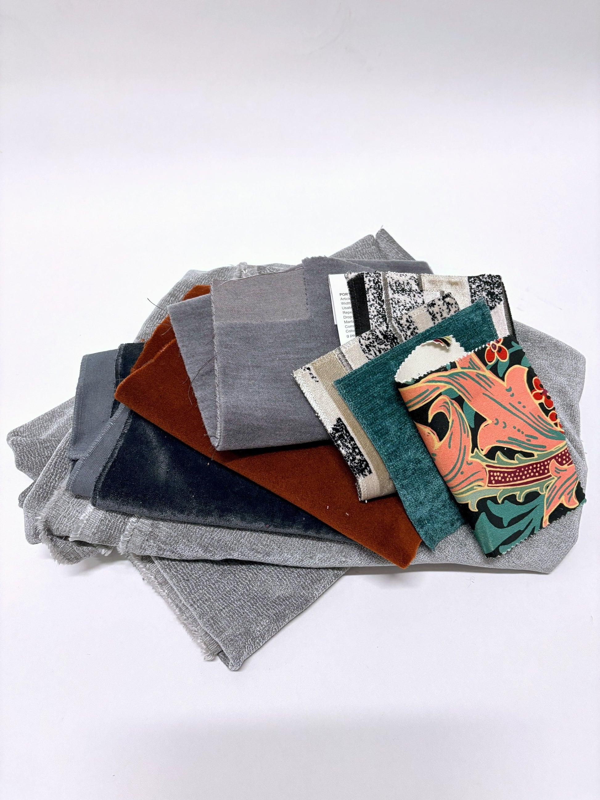 Layered mixed fabric pieces with assorted swatches in varied colours and textures.