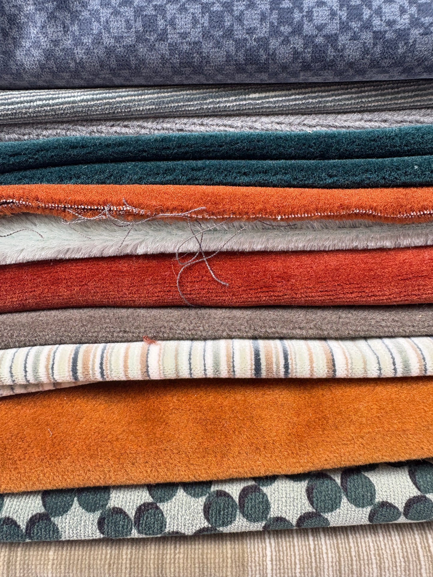 Close-up of layered fabric pieces in assorted colours, textures and patterns.