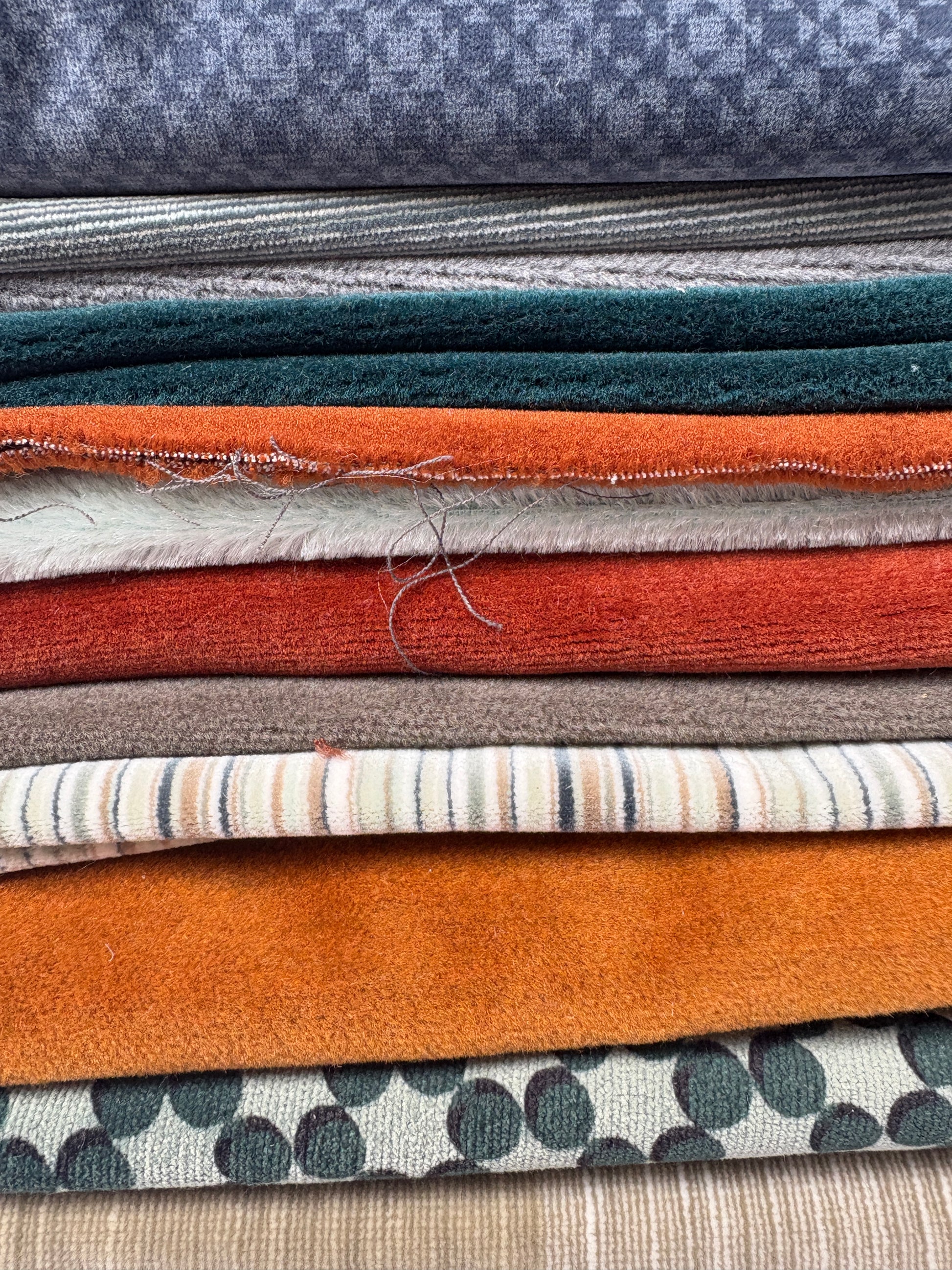 Close-up of layered fabric pieces in assorted colours, textures and patterns.
