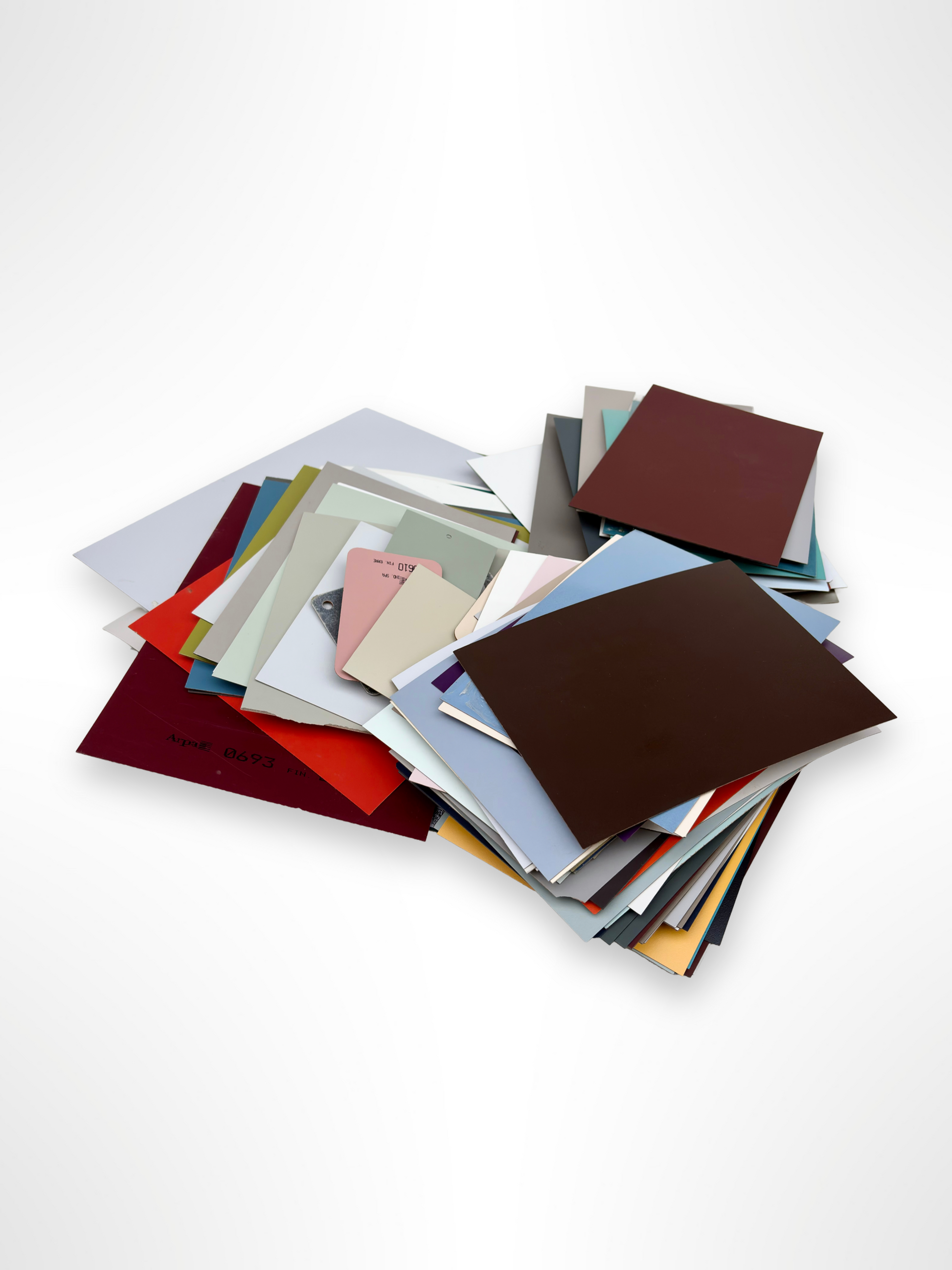 	Coloured sheet samples are stacked in a loose pile on white
