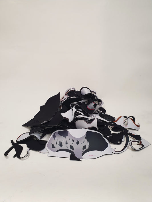 Black and white material offcuts are piled on a white background