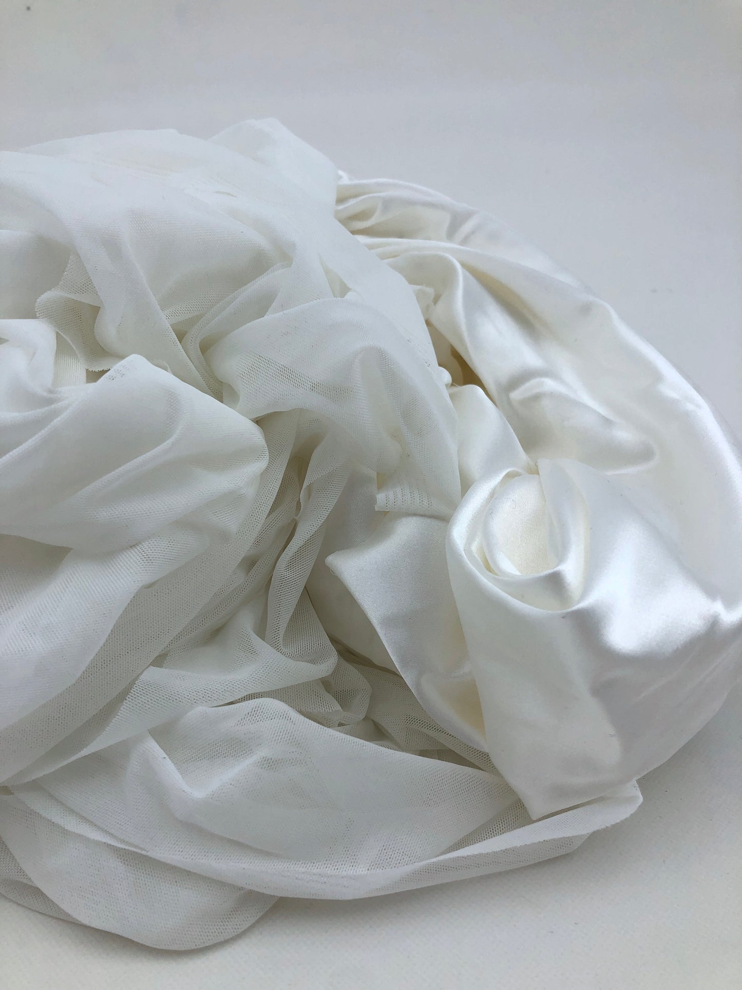 White fabric is shown in detail with smooth and sheer layers