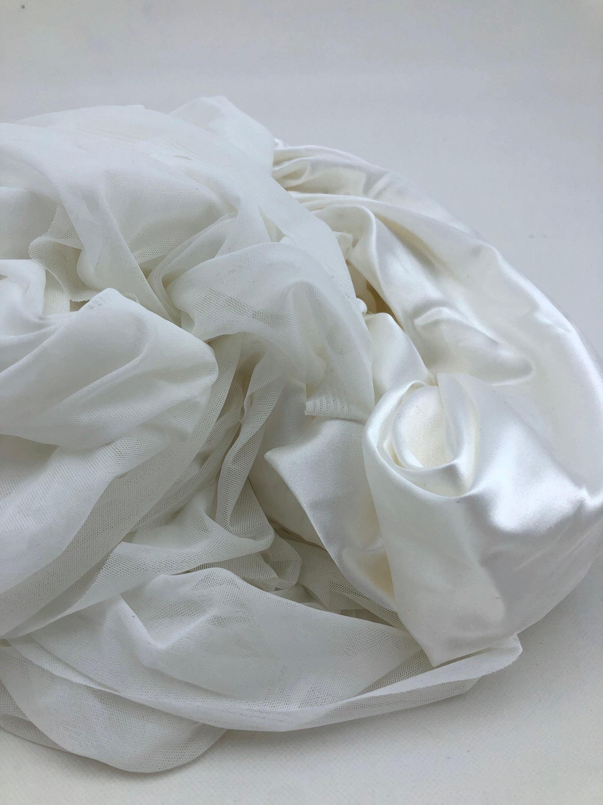 White fabric is shown in detail with smooth and sheer layers