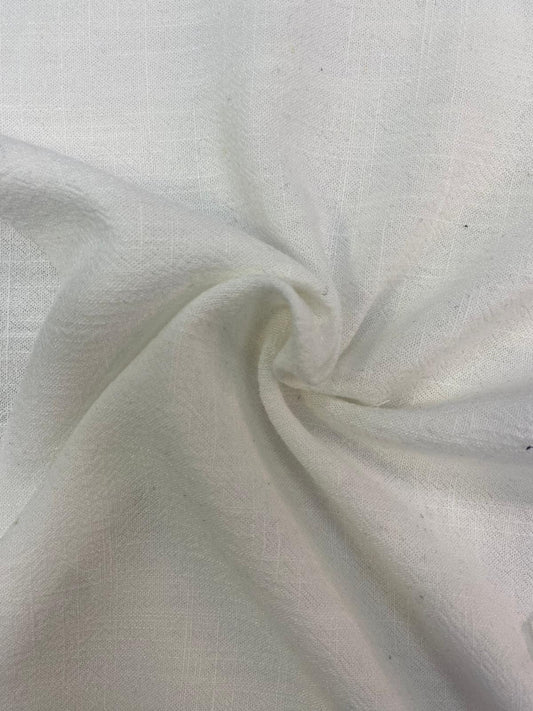 Close-up of white fabric gathered to reveal its soft texture.