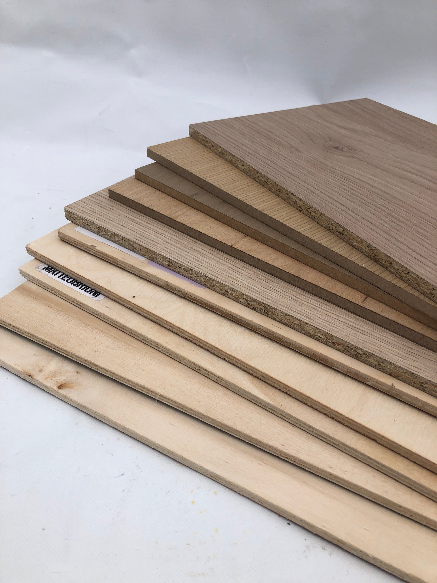 Wood panels are arranged in a tidy stack on a white background